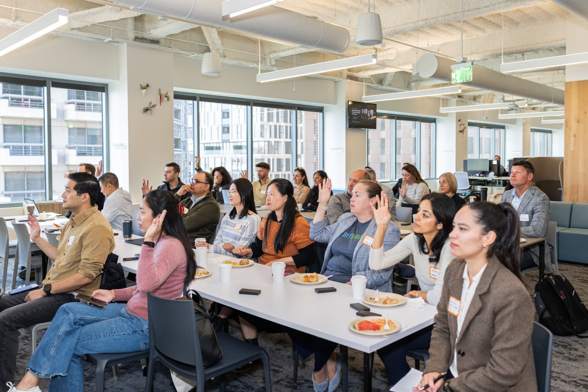 Finance leaders raising their hands in response to a panel question at Airwallex's Beyond the Hype: AI and the Future of Finance breakfast fireside chat at the Airwallex San Francisco office by JY Studio