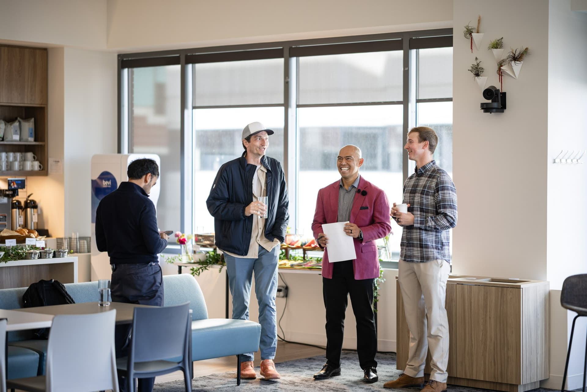Nicolas Kopp, Dean Quiambao, and Drew Armanino chatting by the breakfast buffet before the program at Airwallex's Beyond the Hype: AI and the Future of Finance breakfast fireside chat at the Airwallex San Francisco office by JY Studio