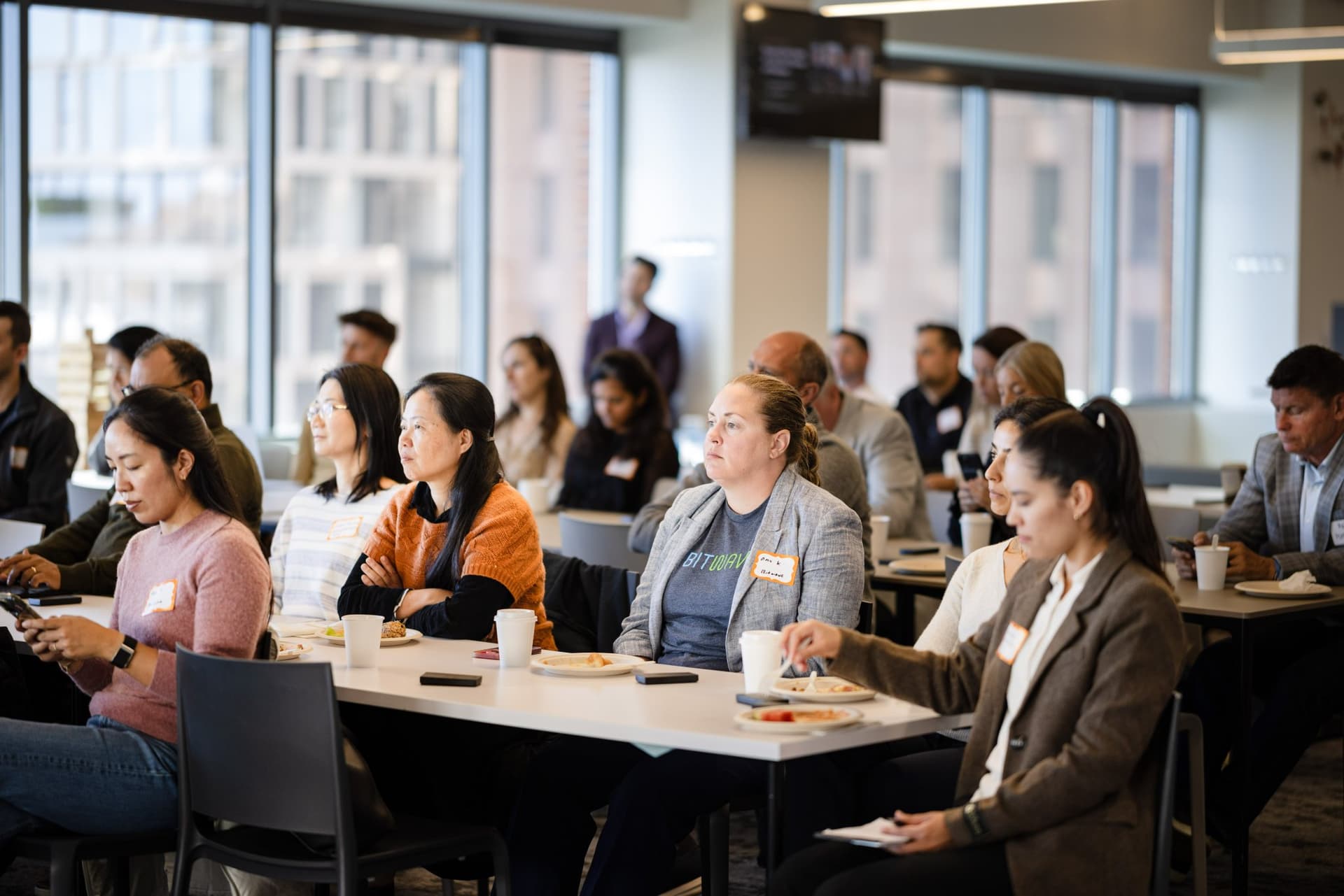 Attendees listening closely at long tables during the panel at Airwallex's Beyond the Hype: AI and the Future of Finance breakfast fireside chat at the Airwallex San Francisco office by JY Studio