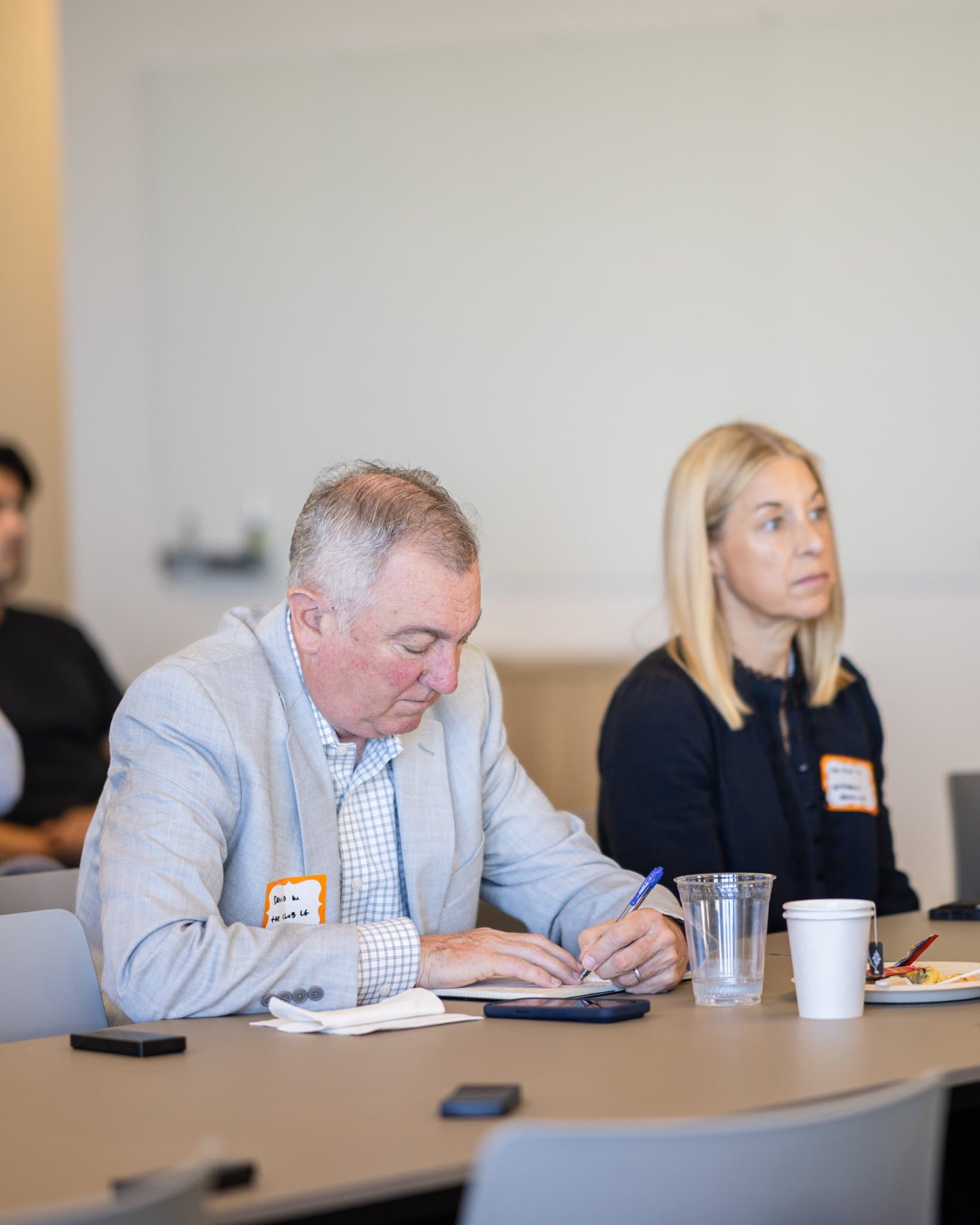 Finance executive taking notes during the panel at Airwallex's Beyond the Hype: AI and the Future of Finance breakfast fireside chat at the Airwallex San Francisco office by JY Studio