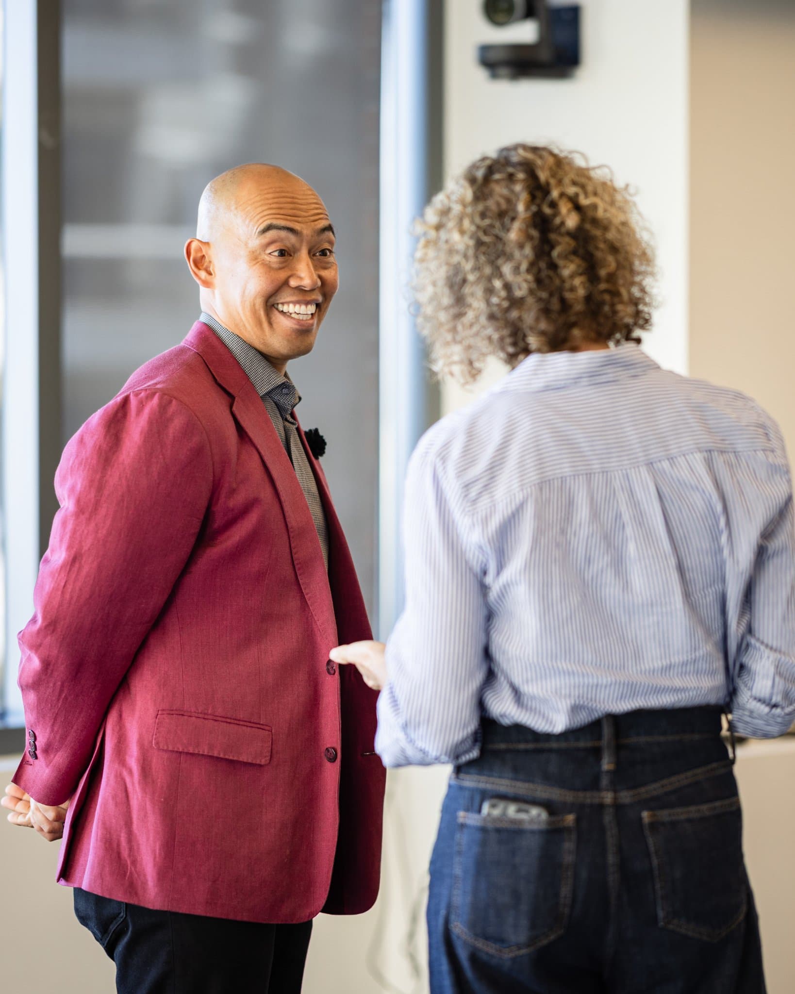 Dean Quiambao sharing a laugh with an attendee at Airwallex's Beyond the Hype: AI and the Future of Finance breakfast fireside chat at the Airwallex San Francisco office by JY Studio