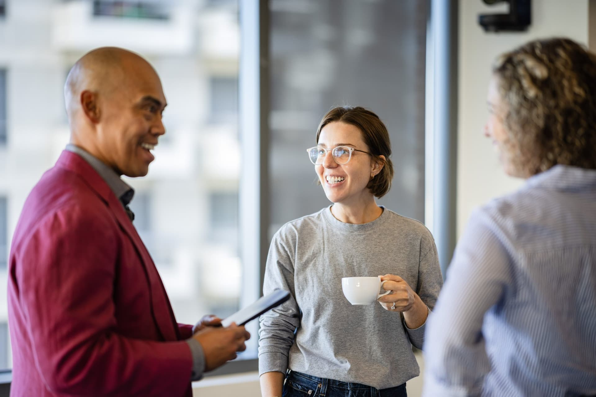 Dean Quiambao chatting with an attendee over coffee at Airwallex's Beyond the Hype: AI and the Future of Finance breakfast fireside chat at the Airwallex San Francisco office by JY Studio
