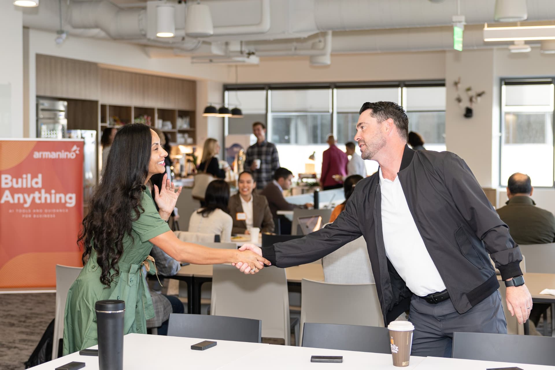 Guests shaking hands beside the Armanino Build Anything banner at Airwallex's Beyond the Hype: AI and the Future of Finance breakfast fireside chat at the Airwallex San Francisco office by JY Studio