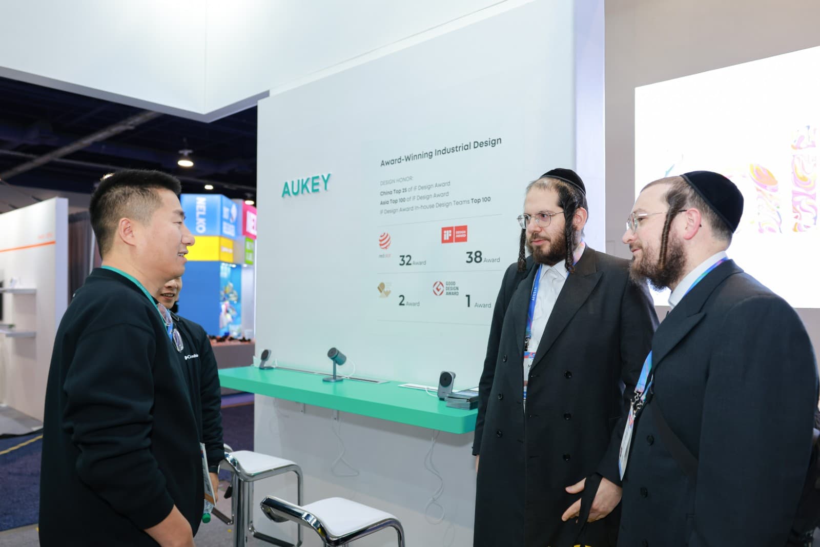 Trade show visitors interacting with AUKEY product demonstrations at CES 2026 Las Vegas convention by JY Studio