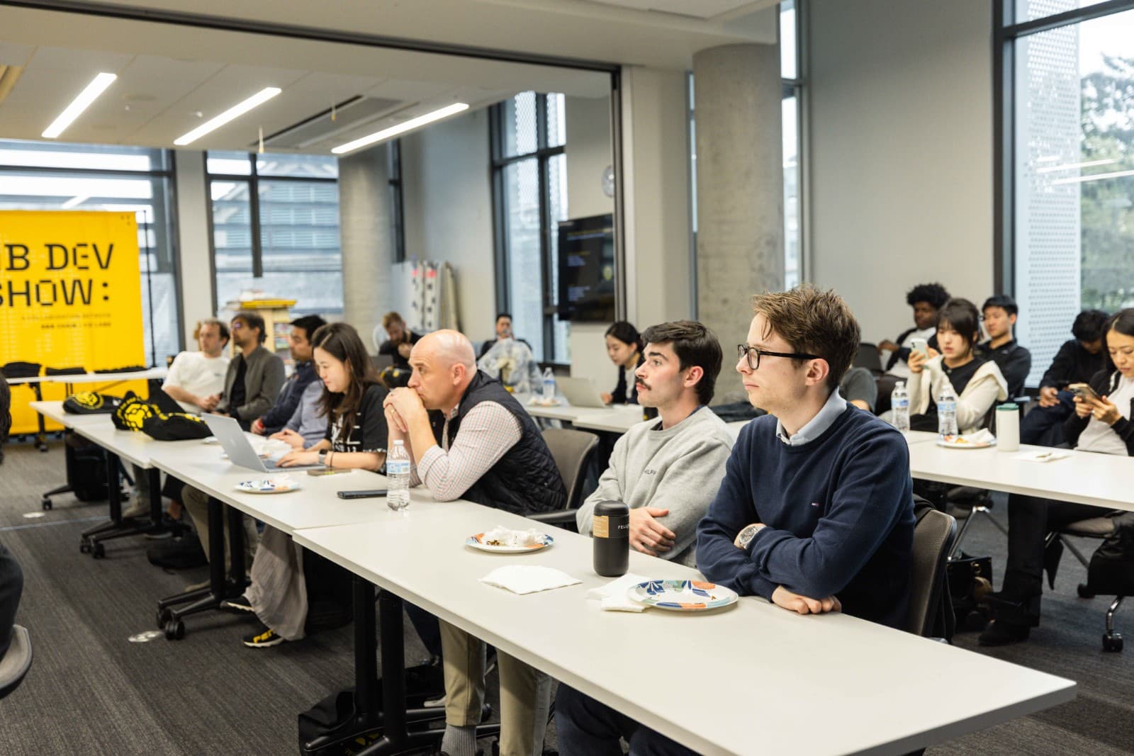 Attendees exploring blockchain project booths at BNB Chain Berkeley event by JY Studio