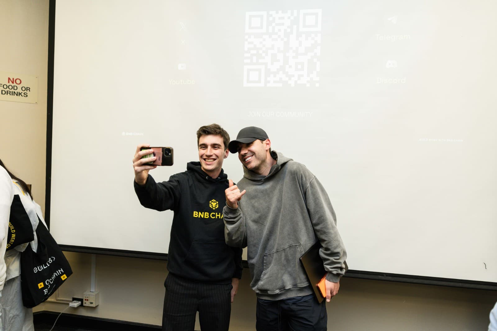 Speaker on stage discussing Binance BNB Chain ecosystem development at Stanford event by JY Studio