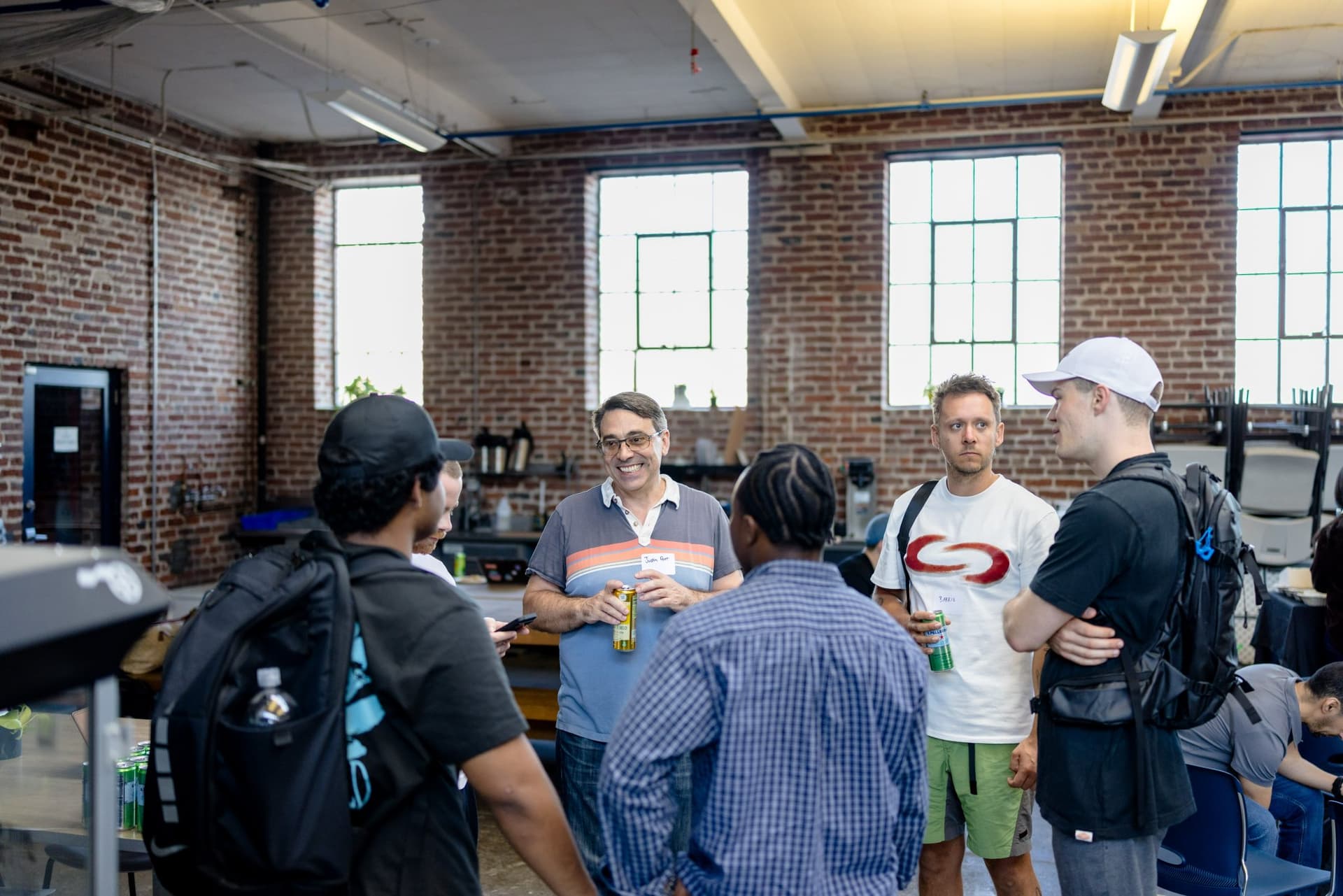 Guests chatting with drinks across the warehouse floor at Clay's Breaking the Mold community networking event during SF Tech Week 2026 in San Francisco by JY Studio