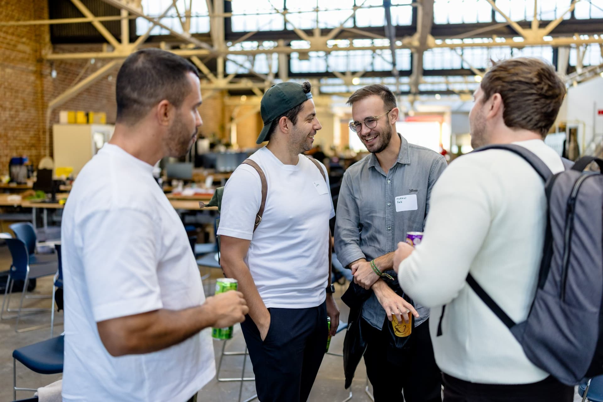 Four guests talking under the warehouse skylights at Clay's Breaking the Mold community networking event during SF Tech Week 2026 in San Francisco by JY Studio