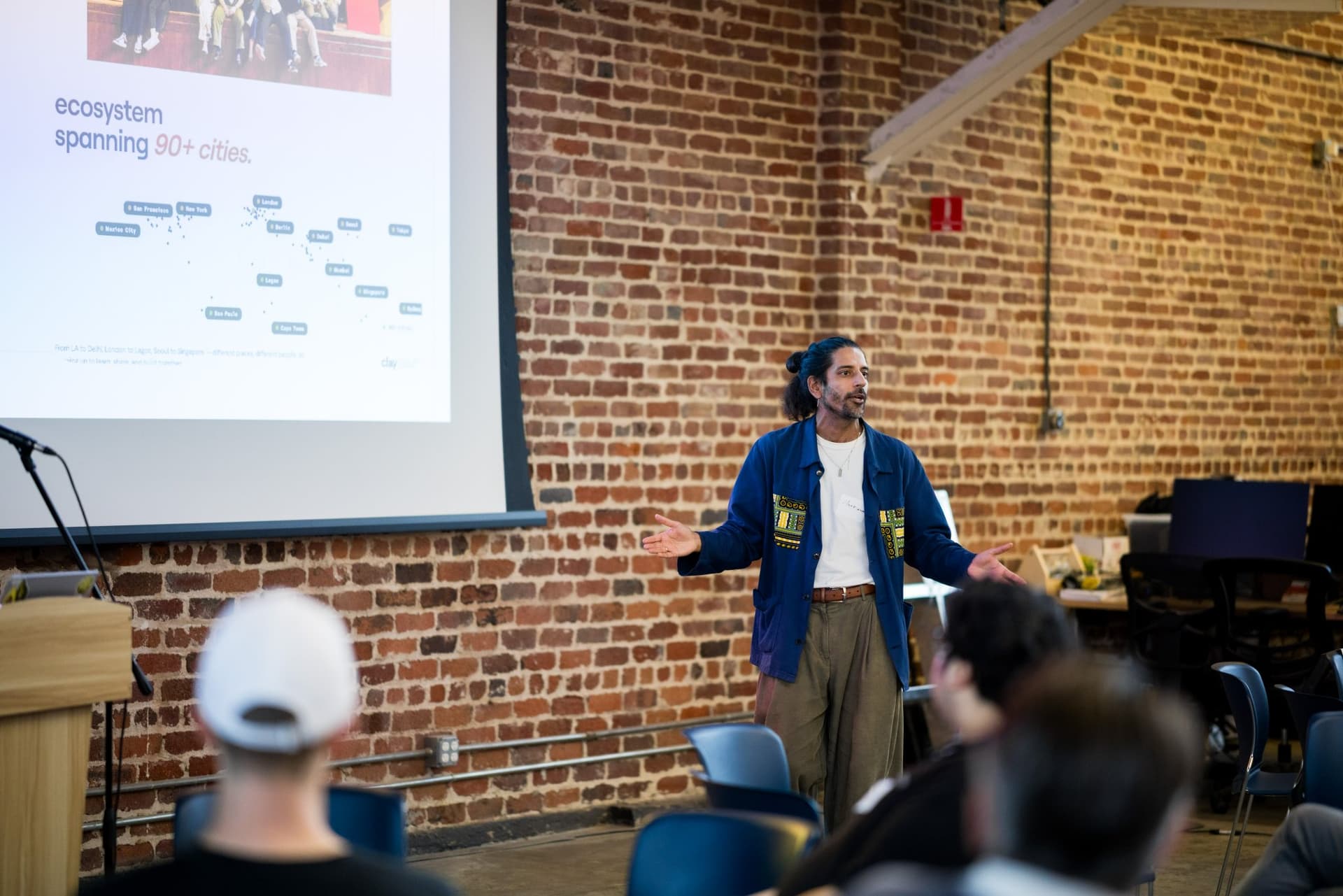 Speaker sharing how the Clay Club ecosystem spans 90+ cities at Clay's Breaking the Mold community networking event during SF Tech Week 2026 in San Francisco by JY Studio