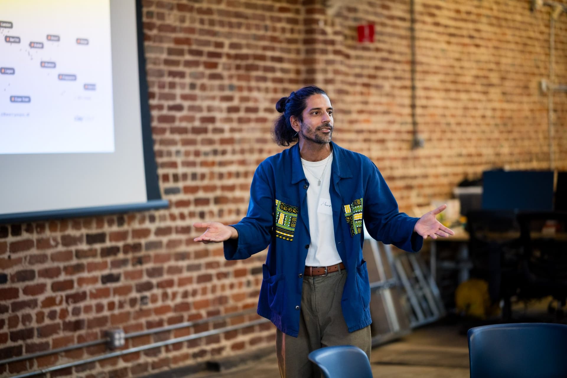 Speaker gesturing to the audience during the community talk at Clay's Breaking the Mold community networking event during SF Tech Week 2026 in San Francisco by JY Studio