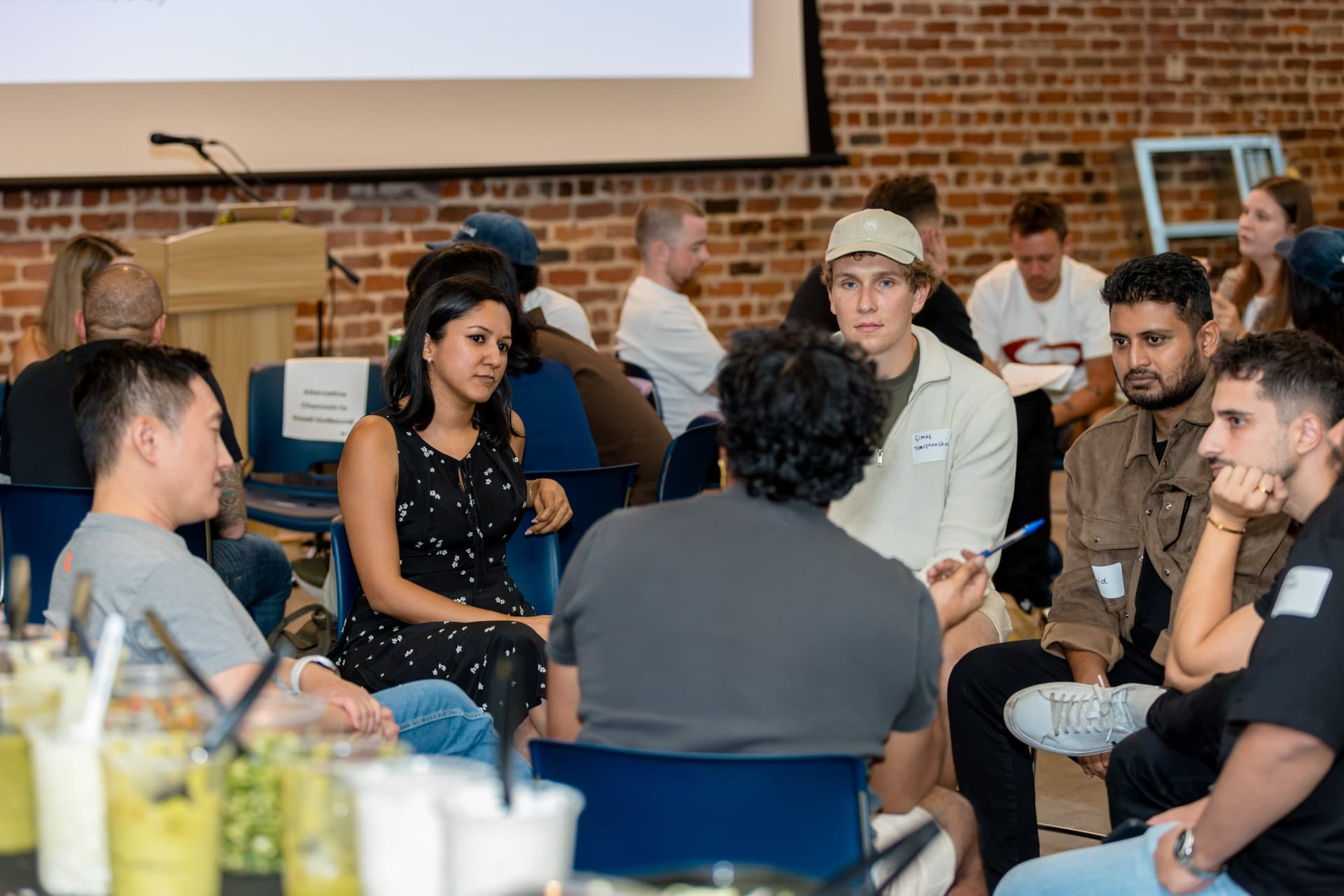 Small-group discussion circle of GTM engineers and operators at Clay's Breaking the Mold community networking event during SF Tech Week 2026 in San Francisco by JY Studio