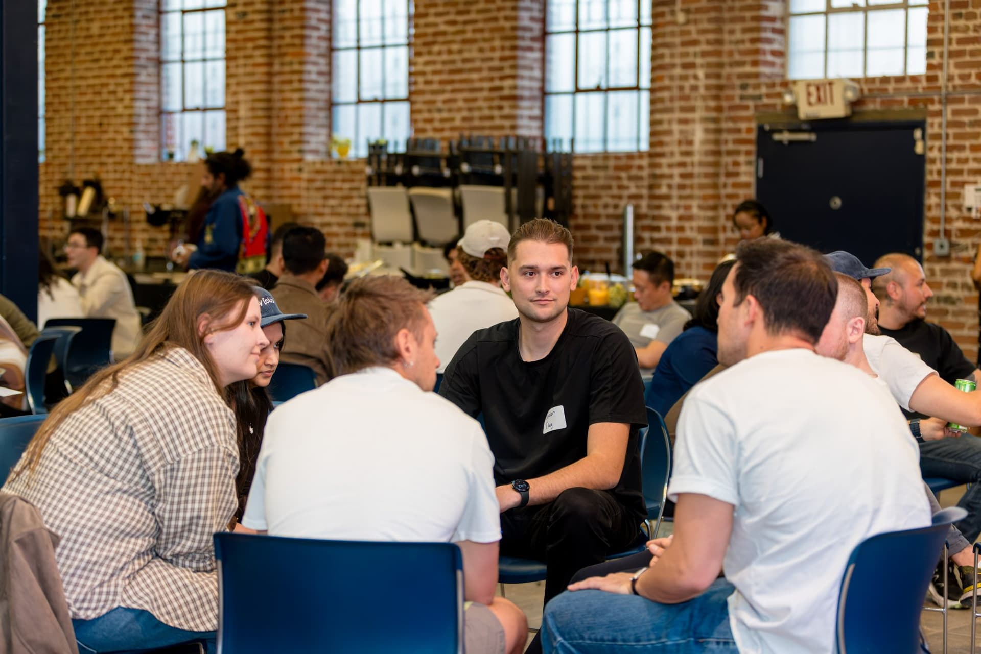 Attendees leaning in during a small-group GTM discussion at Clay's Breaking the Mold community networking event during SF Tech Week 2026 in San Francisco by JY Studio