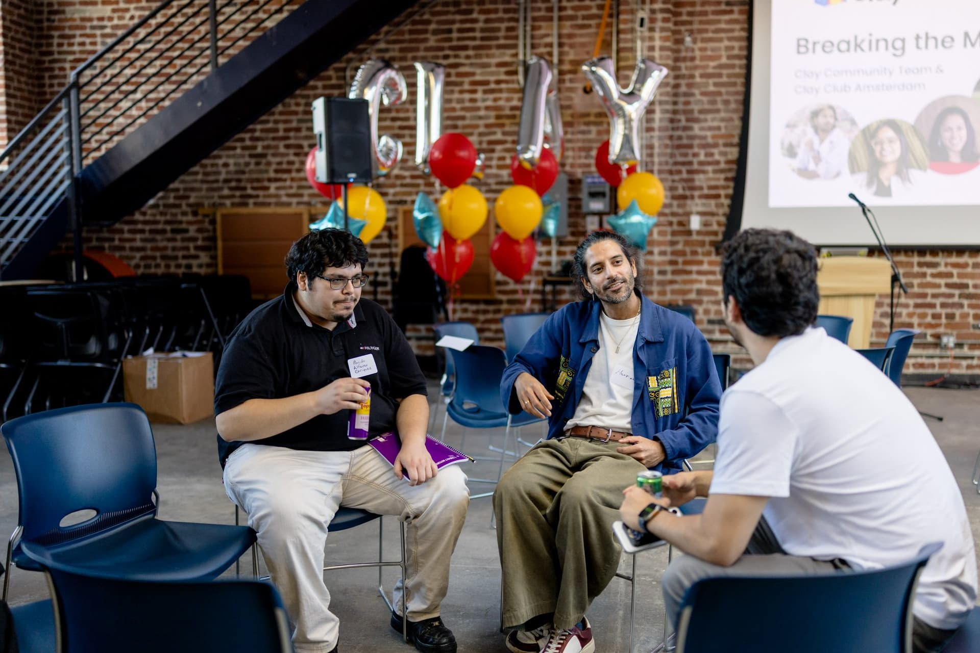 Three attendees talking beside the CLAY balloon letters at Clay's Breaking the Mold community networking event during SF Tech Week 2026 in San Francisco by JY Studio