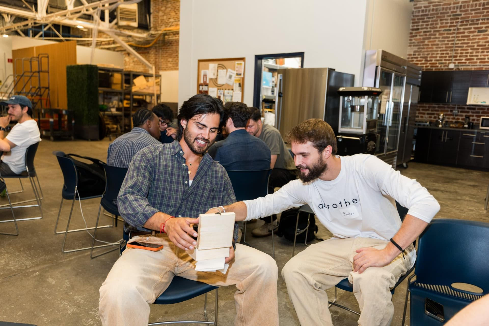 Two attendees reviewing notes together after the discussions at Clay's Breaking the Mold community networking event during SF Tech Week 2026 in San Francisco by JY Studio