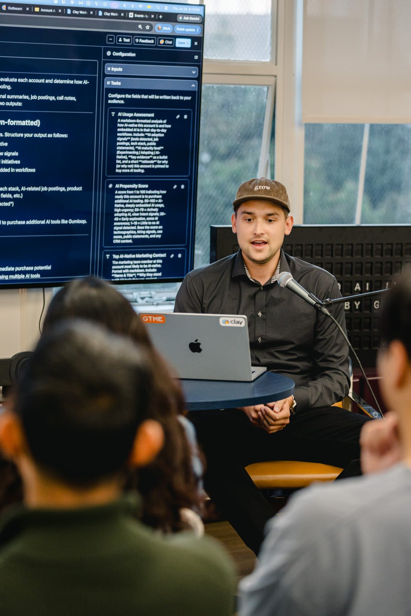 Speaker walking through a marketing automation dashboard during the Gumloop demo night in San Francisco