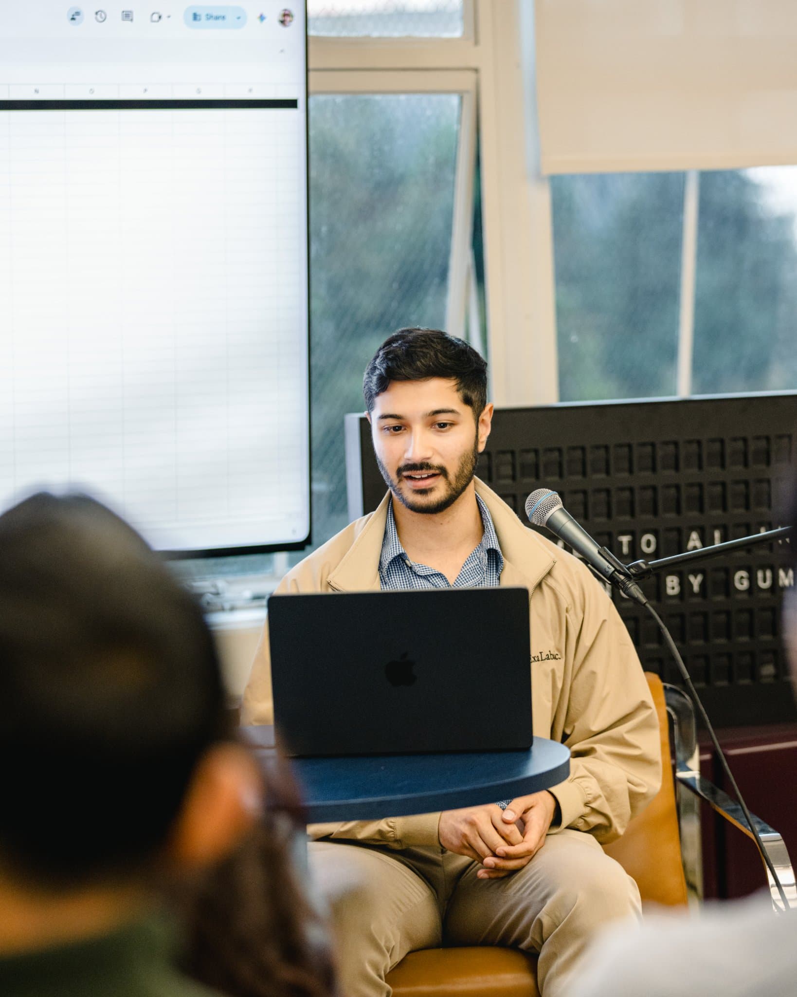 Guest speaker seated with a laptop demonstrating an AI sales workflow at Gumloop in San Francisco