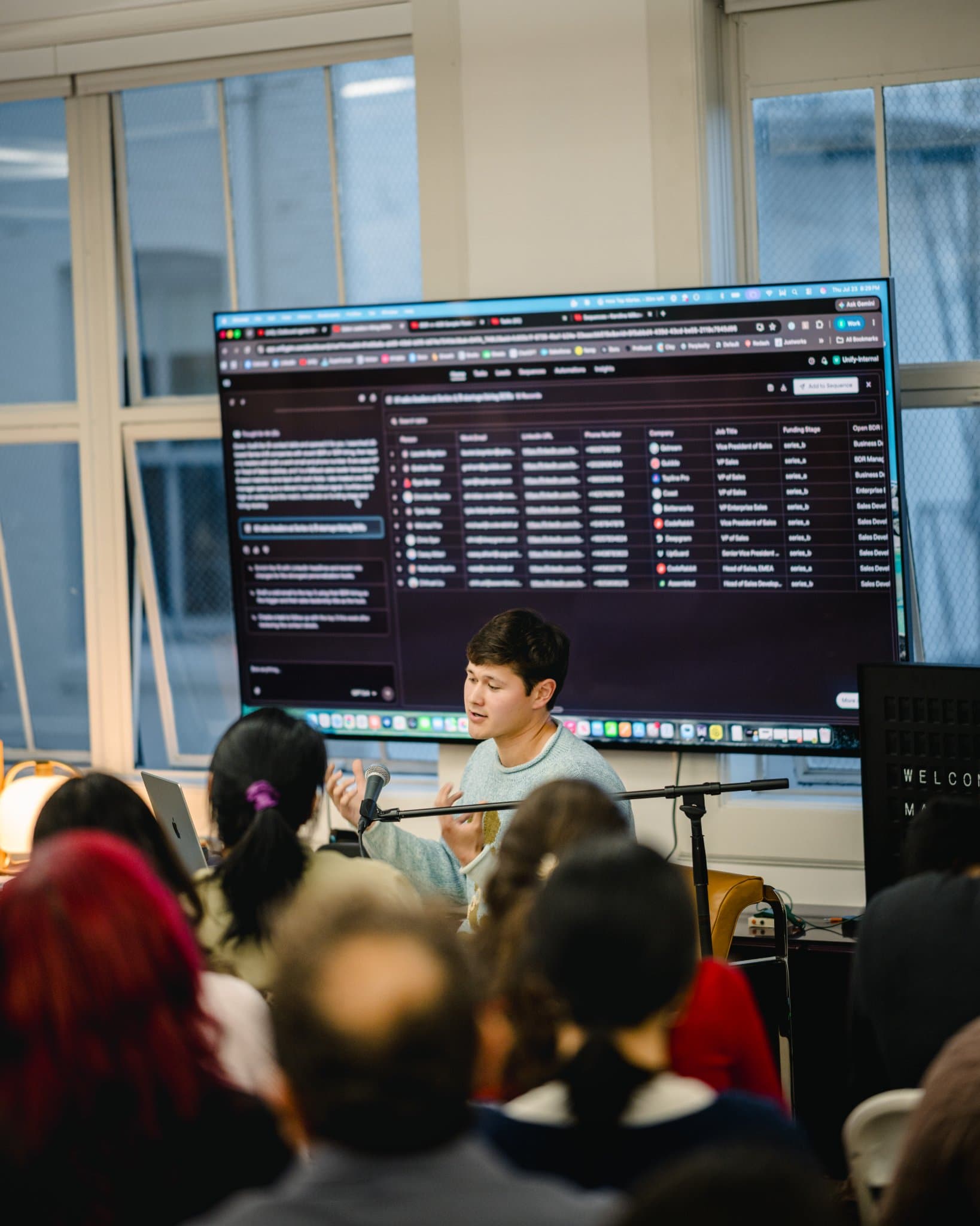 Presenter in a casual sweater discussing outbound marketing agents at the Gumloop meetup in San Francisco