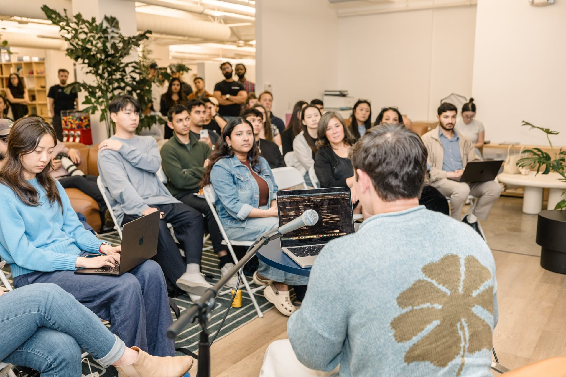 Guest reacting with a raised hand during Q&A at the Gumloop marketing meetup in San Francisco