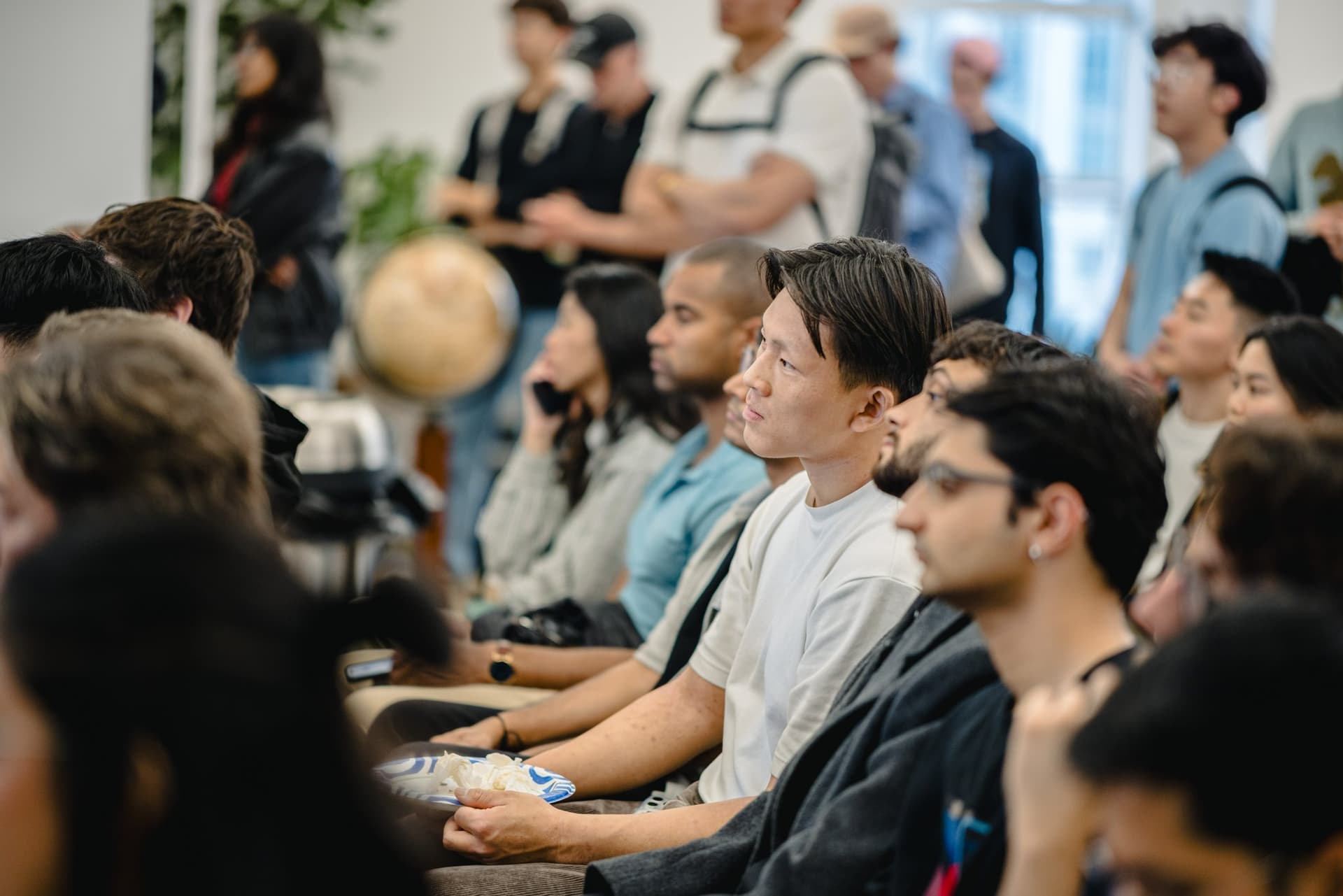 Attendees listening attentively near the back of the room at the Gumloop meetup in San Francisco