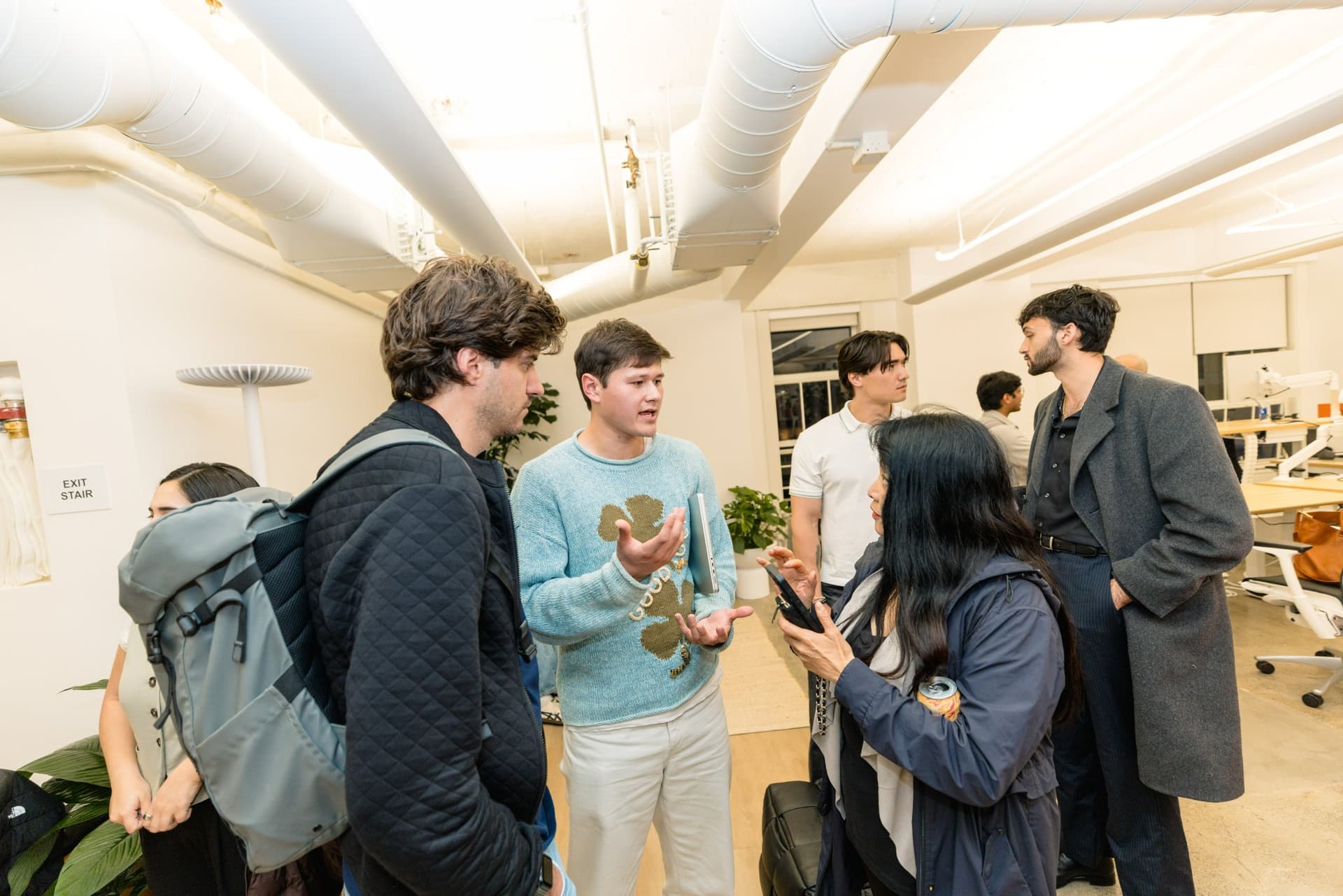 Guests gathered around a laptop continuing the conversation after the Gumloop marketing meetup