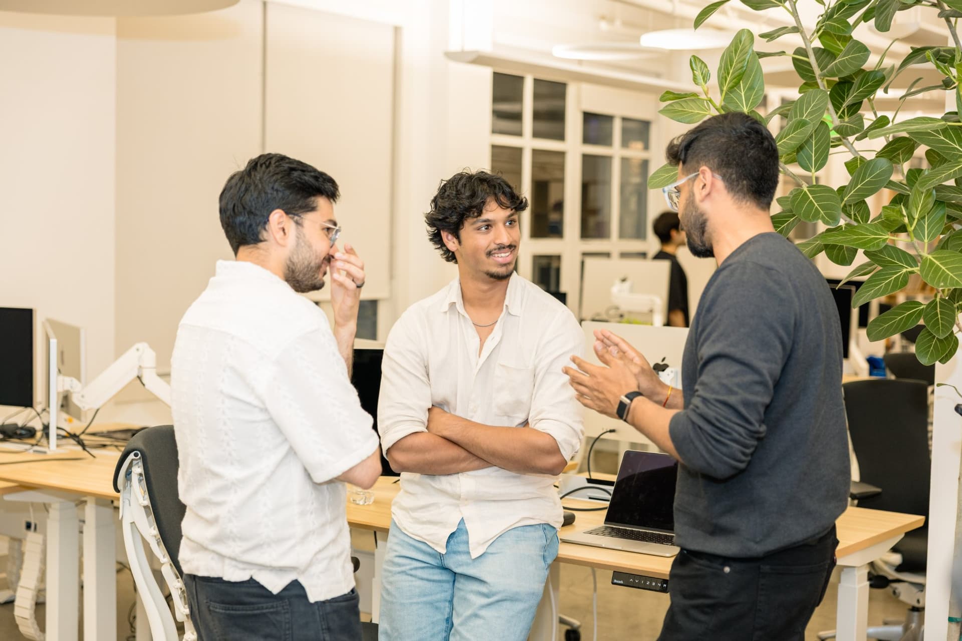 Attendees wrapping up conversations near the workstations at the close of the Gumloop meetup in San Francisco