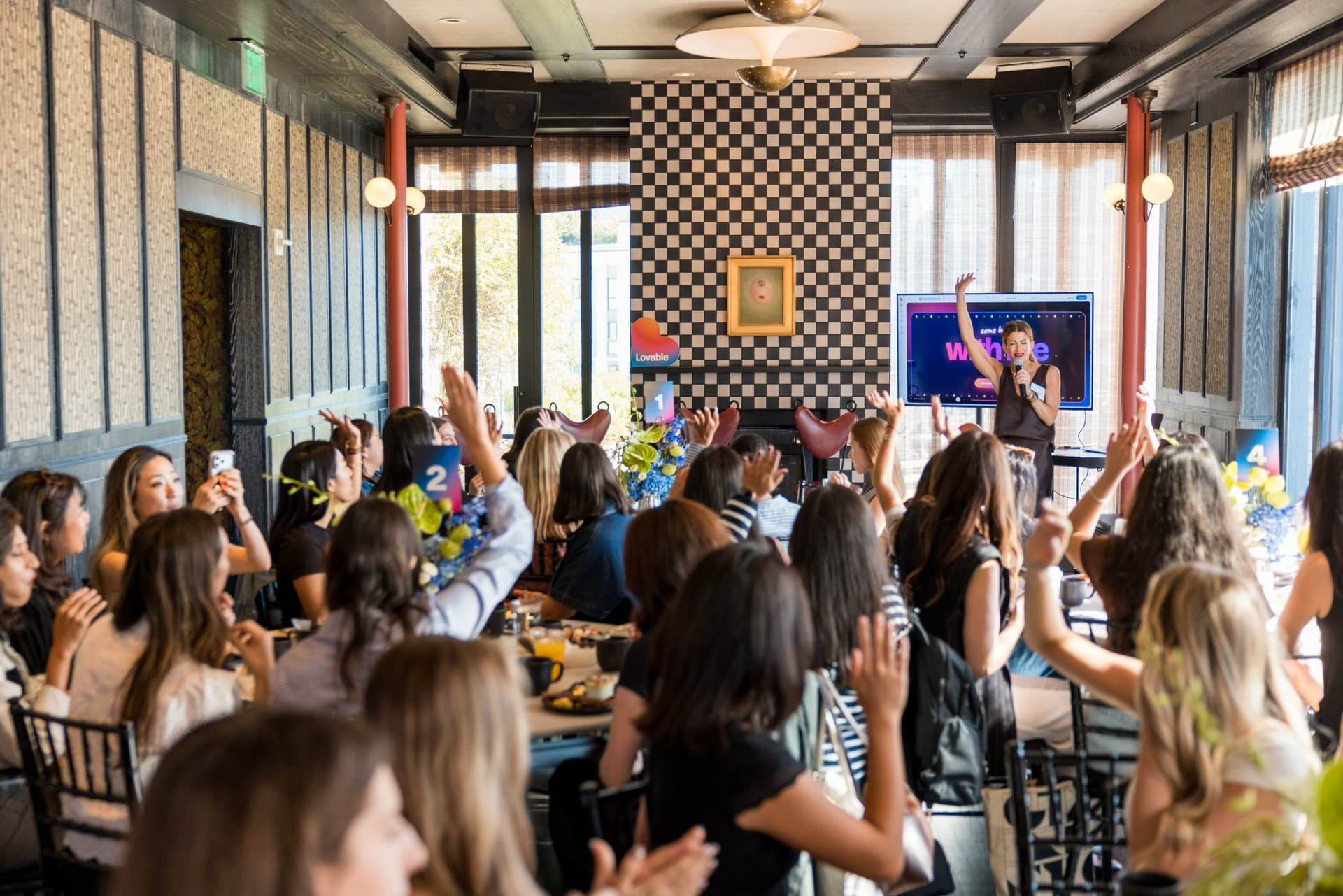 Guests raising their hands in response to the host's opening question at Lovable x Wispr Flow's Built on Her Terms brunch roundtable during SF Tech Week 2026 in San Francisco by JY Studio