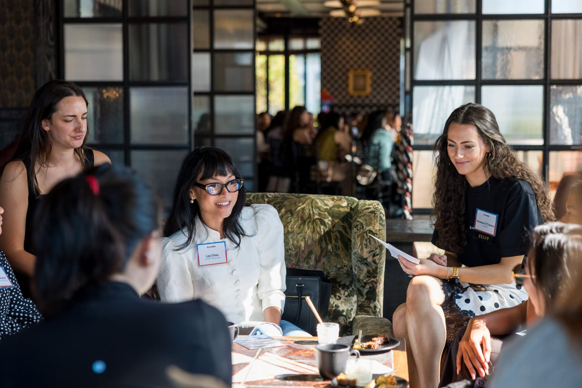 Women in tech discussing the roundtable guide at a brunch table at Lovable x Wispr Flow's Built on Her Terms brunch roundtable during SF Tech Week 2026 in San Francisco by JY Studio