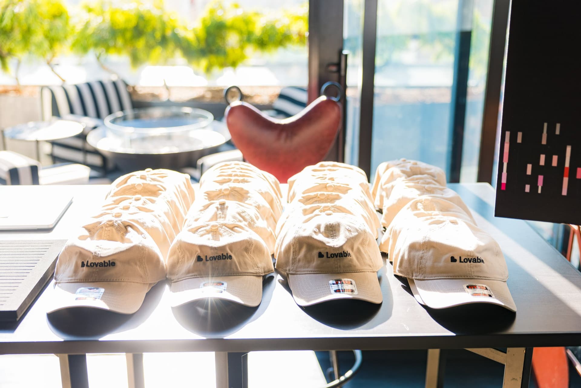 Lovable branded caps lined up on the merch table at Lovable x Wispr Flow's Built on Her Terms brunch roundtable during SF Tech Week 2026 in San Francisco by JY Studio