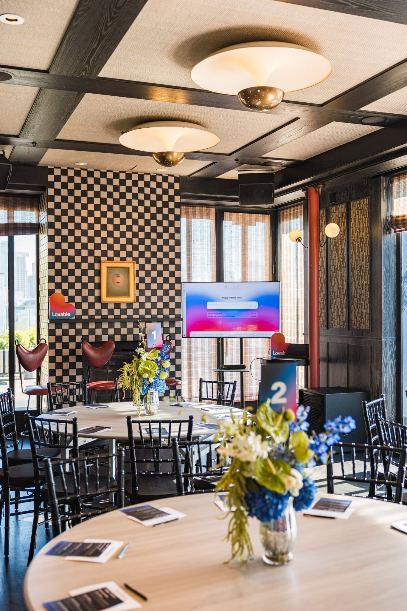 Round brunch tables with floral centerpieces and discussion guides set up for the roundtable at Lovable x Wispr Flow's Built on Her Terms brunch roundtable during SF Tech Week 2026 in San Francisco by JY Studio