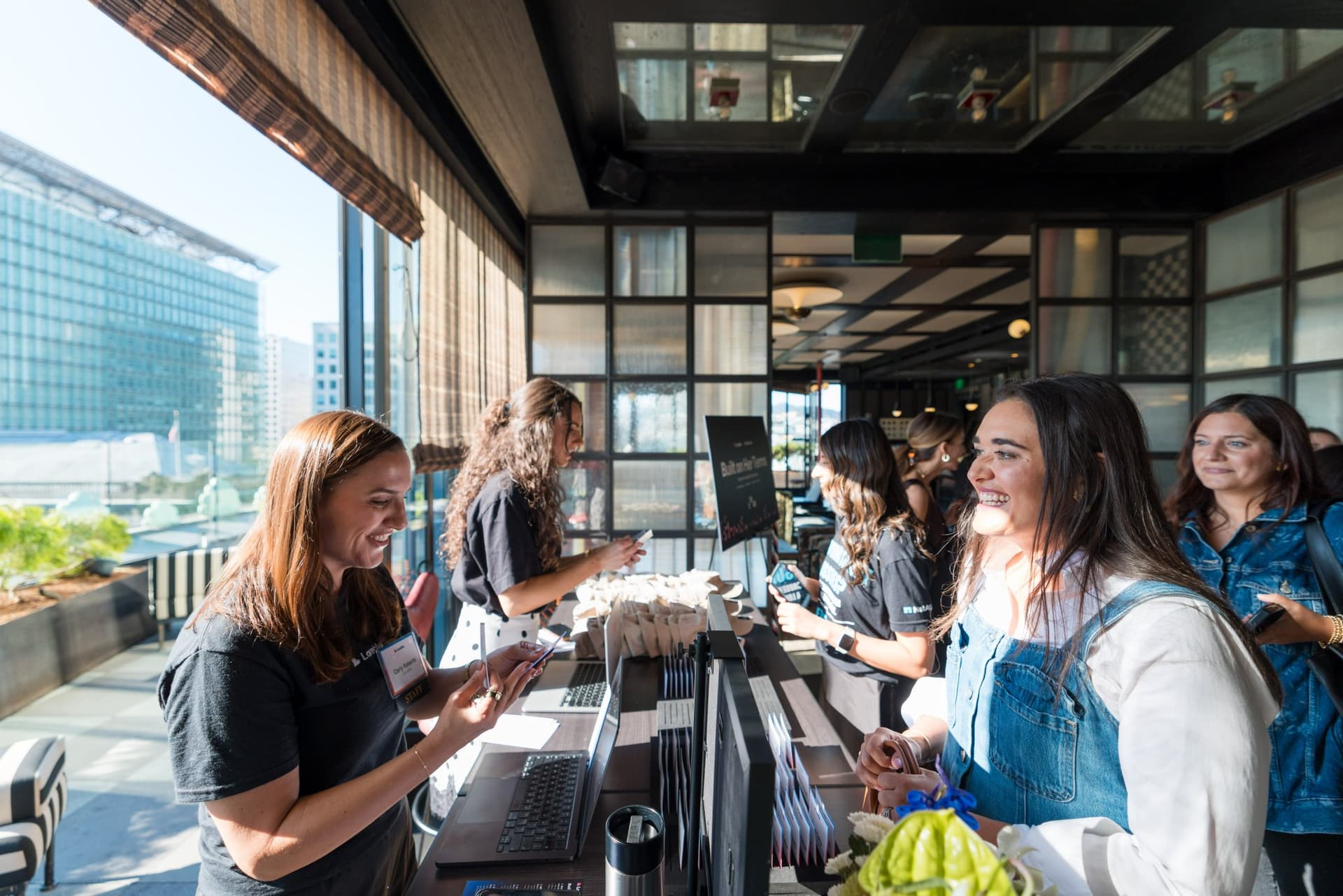 Lovable team checking in guests at the registration table at Lovable x Wispr Flow's Built on Her Terms brunch roundtable during SF Tech Week 2026 in San Francisco by JY Studio