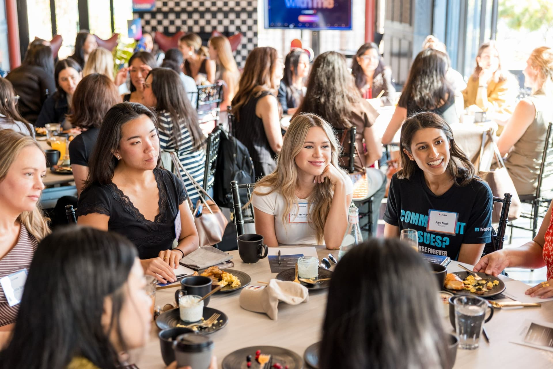 Women smiling and listening during a brunch roundtable conversation at Lovable x Wispr Flow's Built on Her Terms brunch roundtable during SF Tech Week 2026 in San Francisco by JY Studio