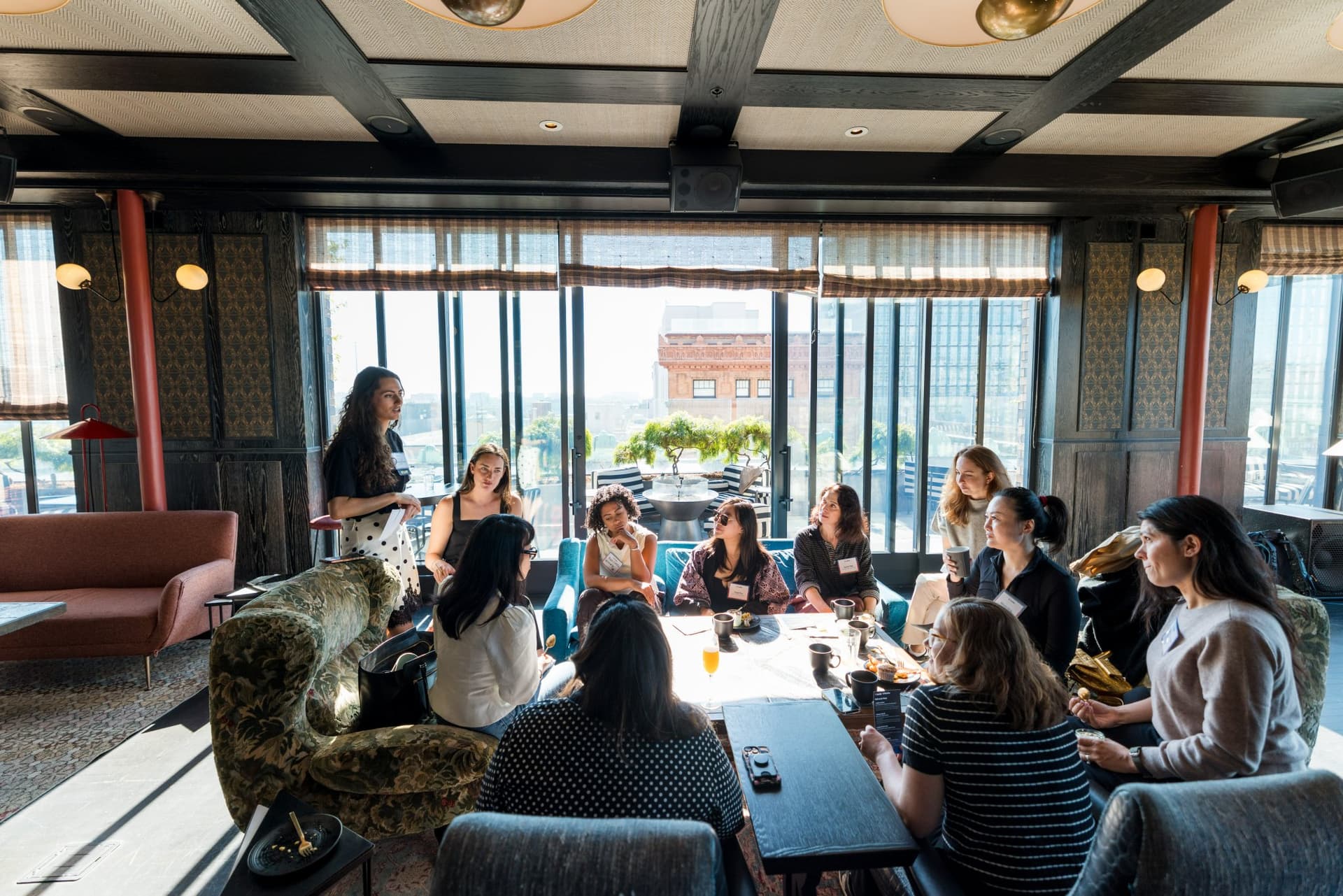 Lounge group gathered around a coffee table for the roundtable discussion at Lovable x Wispr Flow's Built on Her Terms brunch roundtable during SF Tech Week 2026 in San Francisco by JY Studio