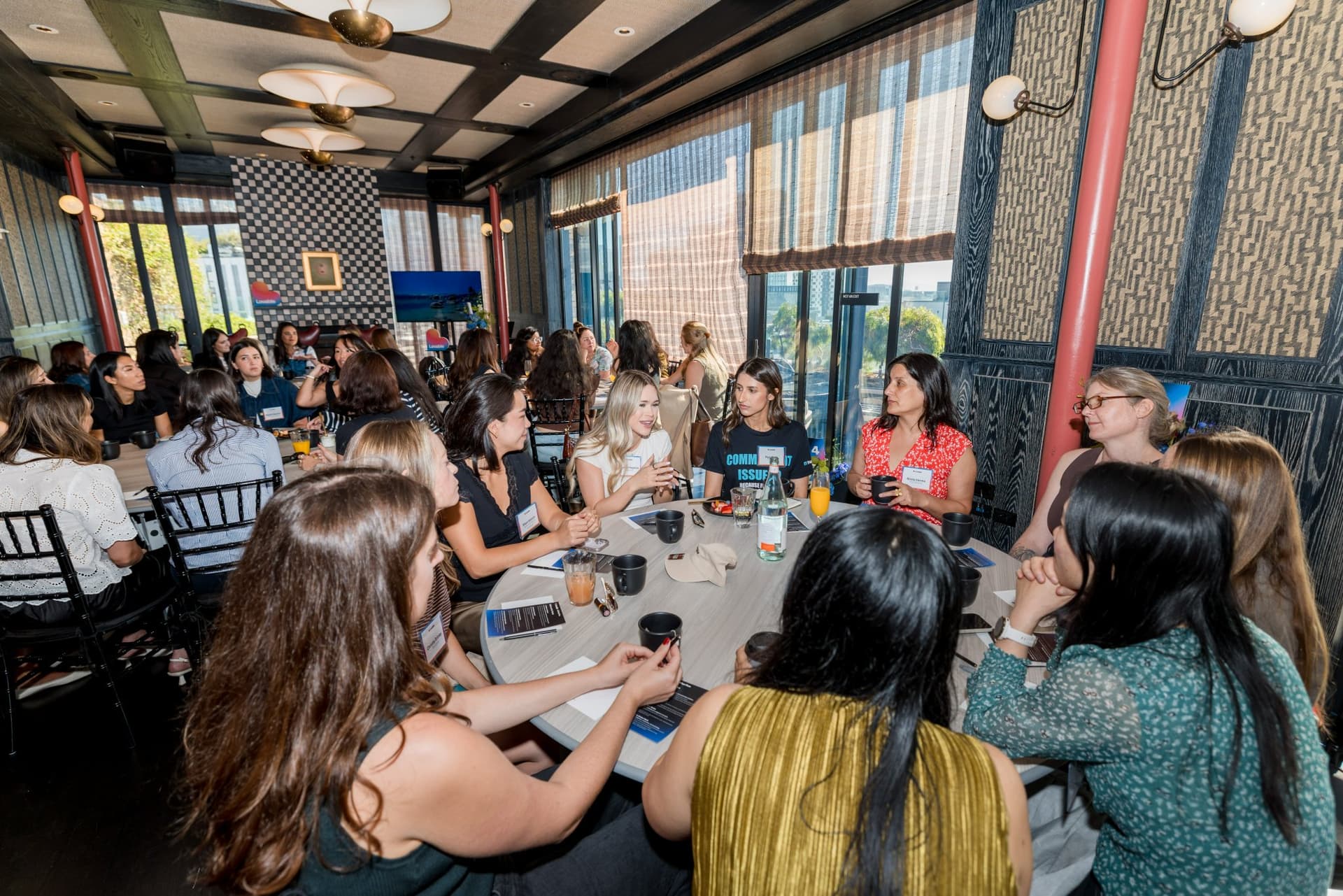 Large brunch table of women discussing AI and ambition at Lovable x Wispr Flow's Built on Her Terms brunch roundtable during SF Tech Week 2026 in San Francisco by JY Studio