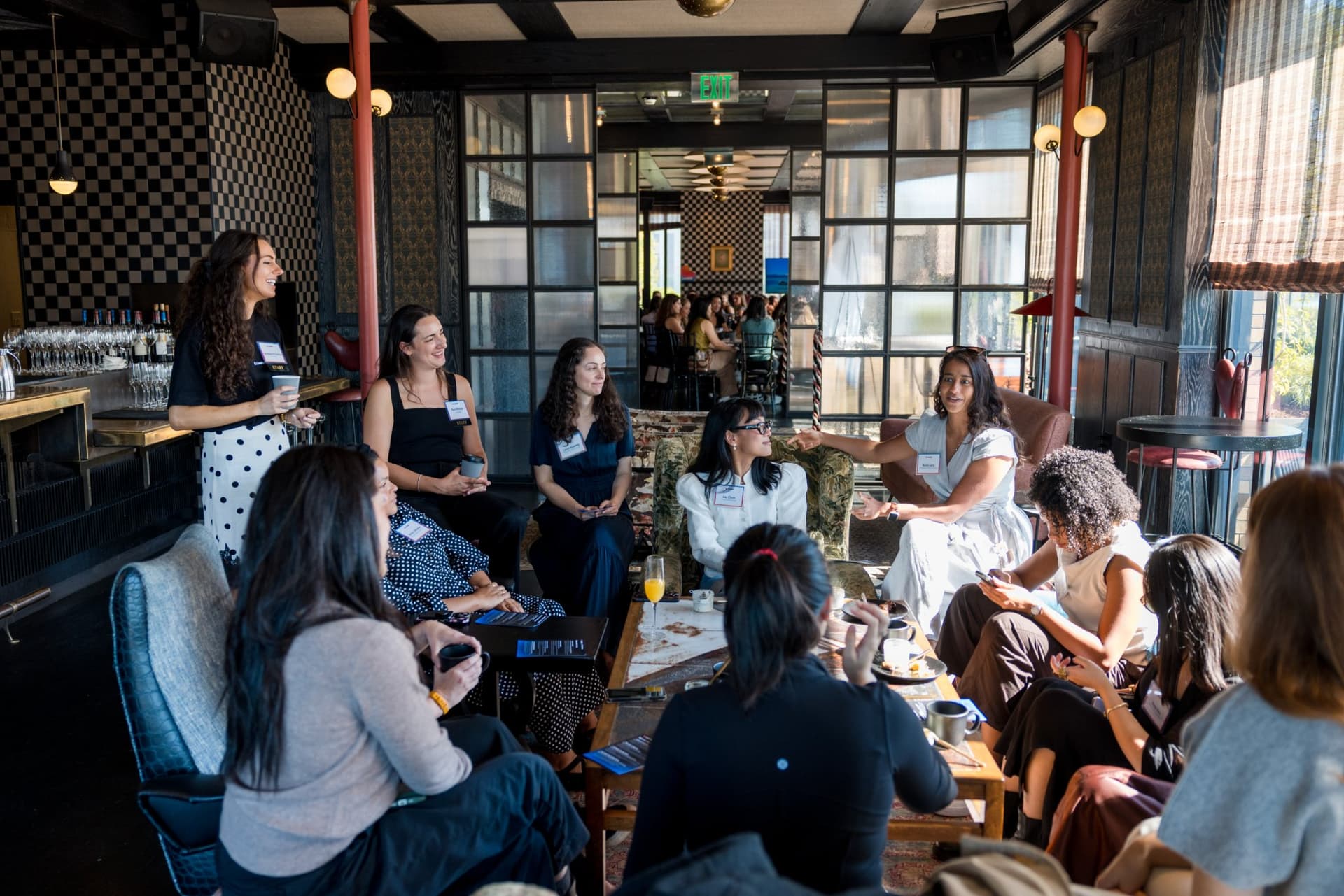 Lounge circle of women in tech sharing stories at Lovable x Wispr Flow's Built on Her Terms brunch roundtable during SF Tech Week 2026 in San Francisco by JY Studio