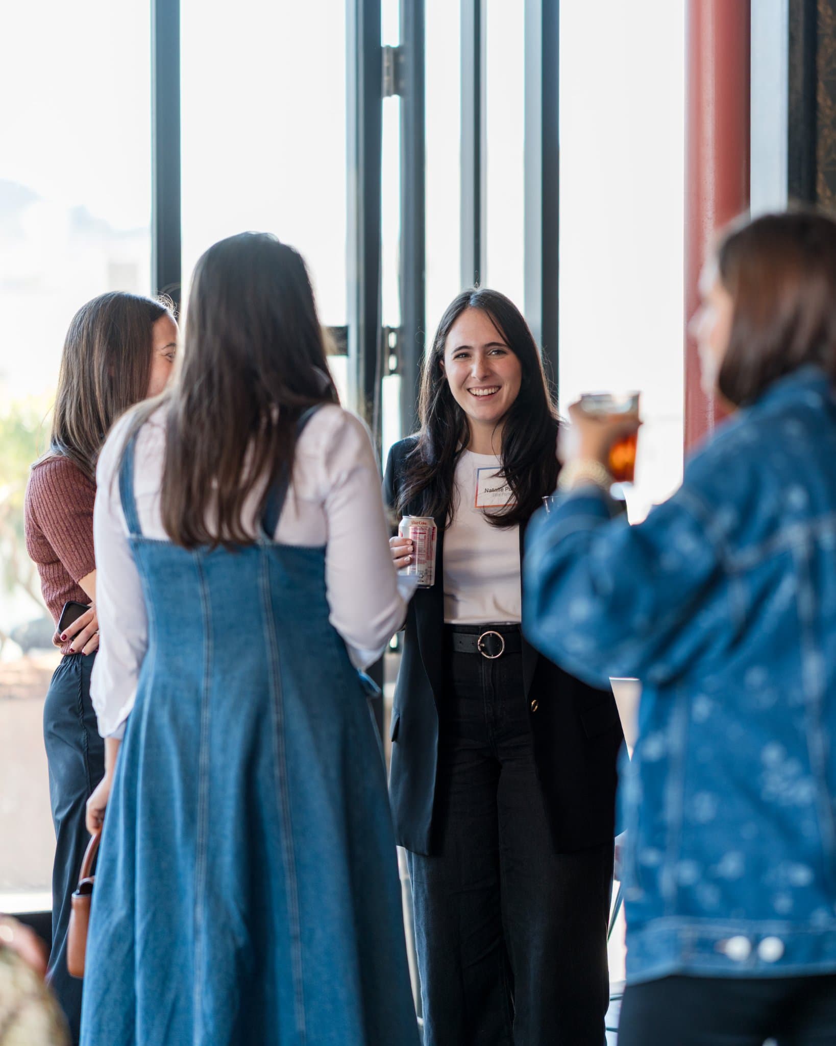 Guests networking with drinks by the windows after the discussion at Lovable x Wispr Flow's Built on Her Terms brunch roundtable during SF Tech Week 2026 in San Francisco by JY Studio