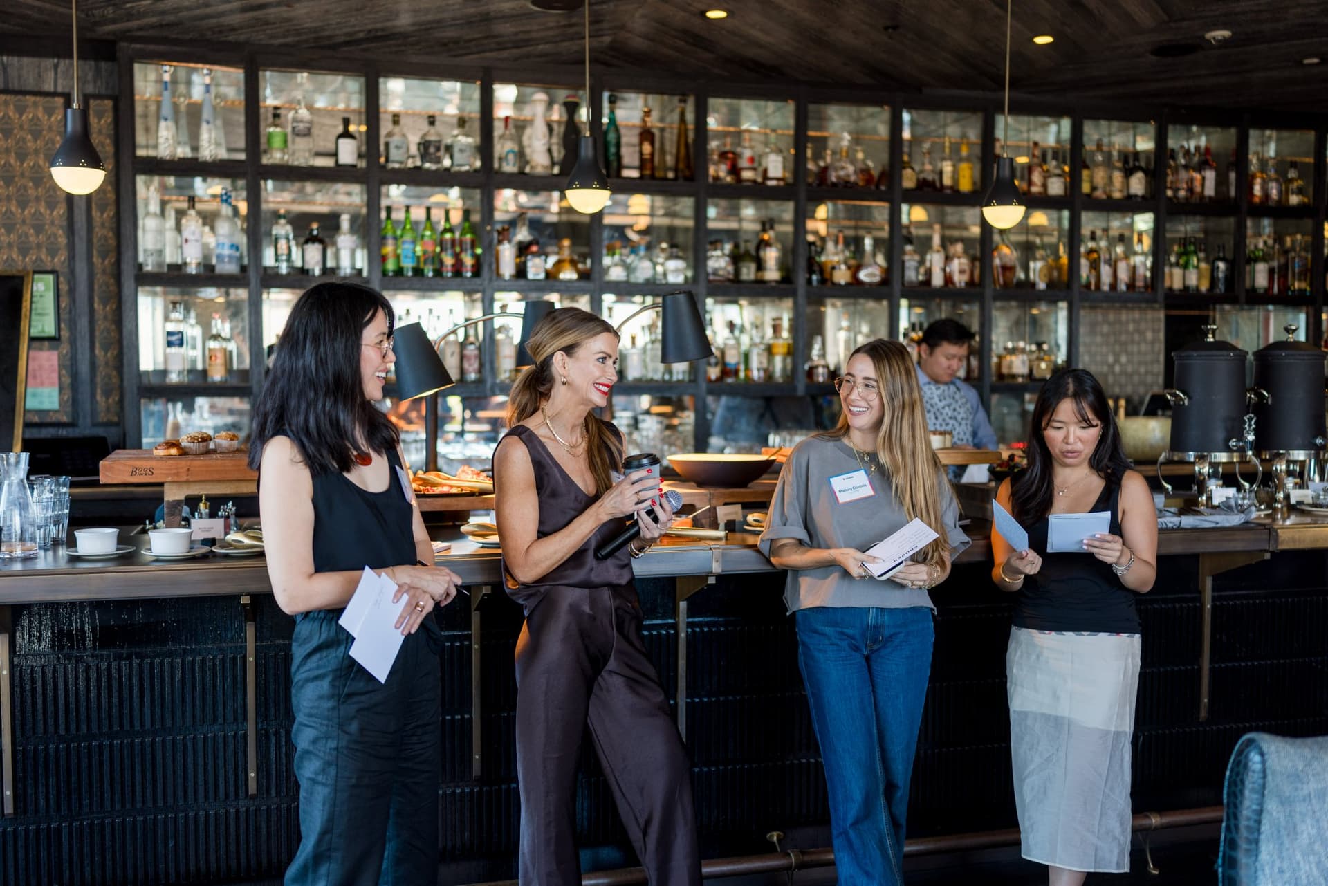 Lovable and Wispr Flow hosts reading discussion takeaways at the bar at Lovable x Wispr Flow's Built on Her Terms brunch roundtable during SF Tech Week 2026 in San Francisco by JY Studio