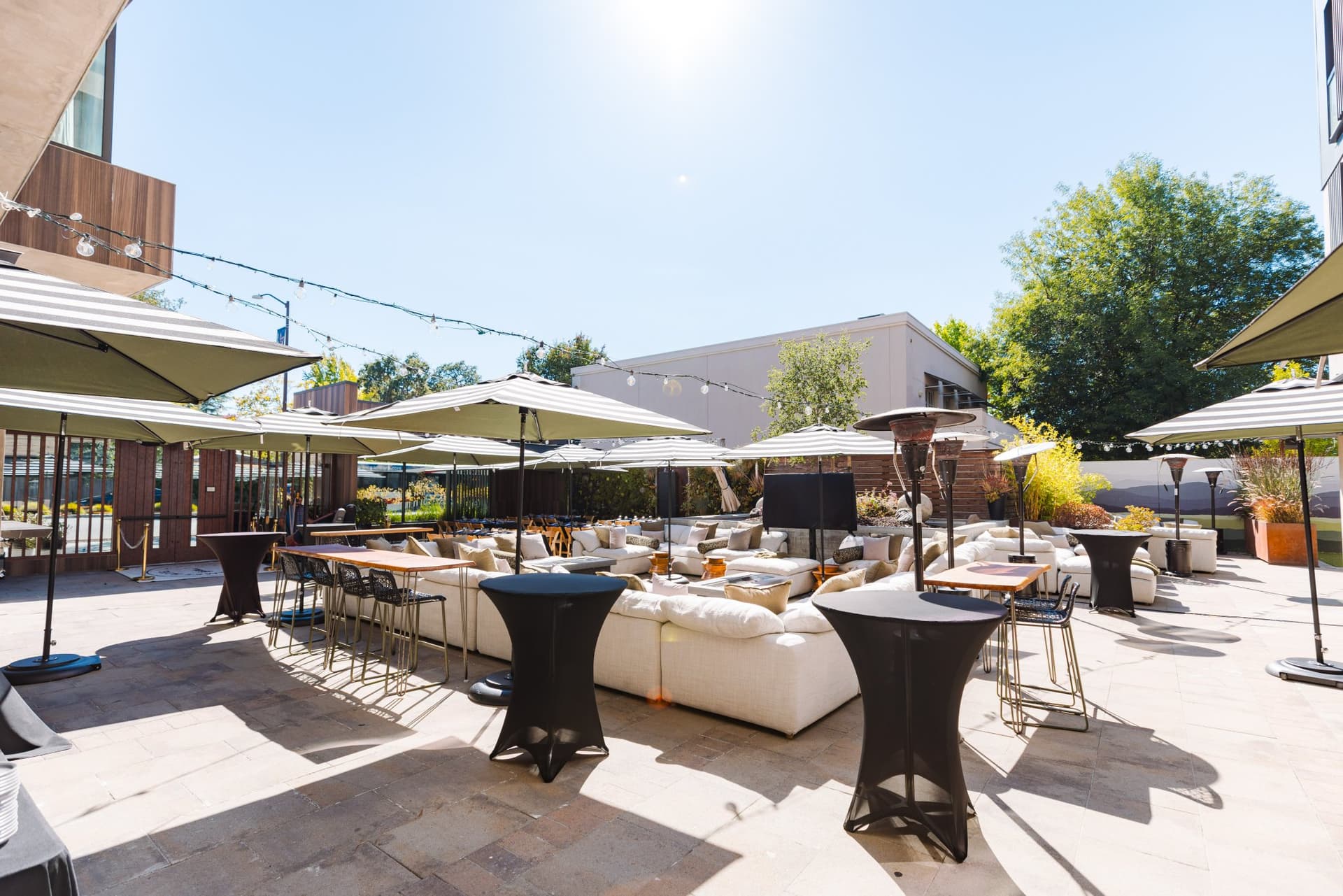 Sun-drenched patio venue with lounge seating and cocktail tables prepared for the Magnus gathering in Palo Alto