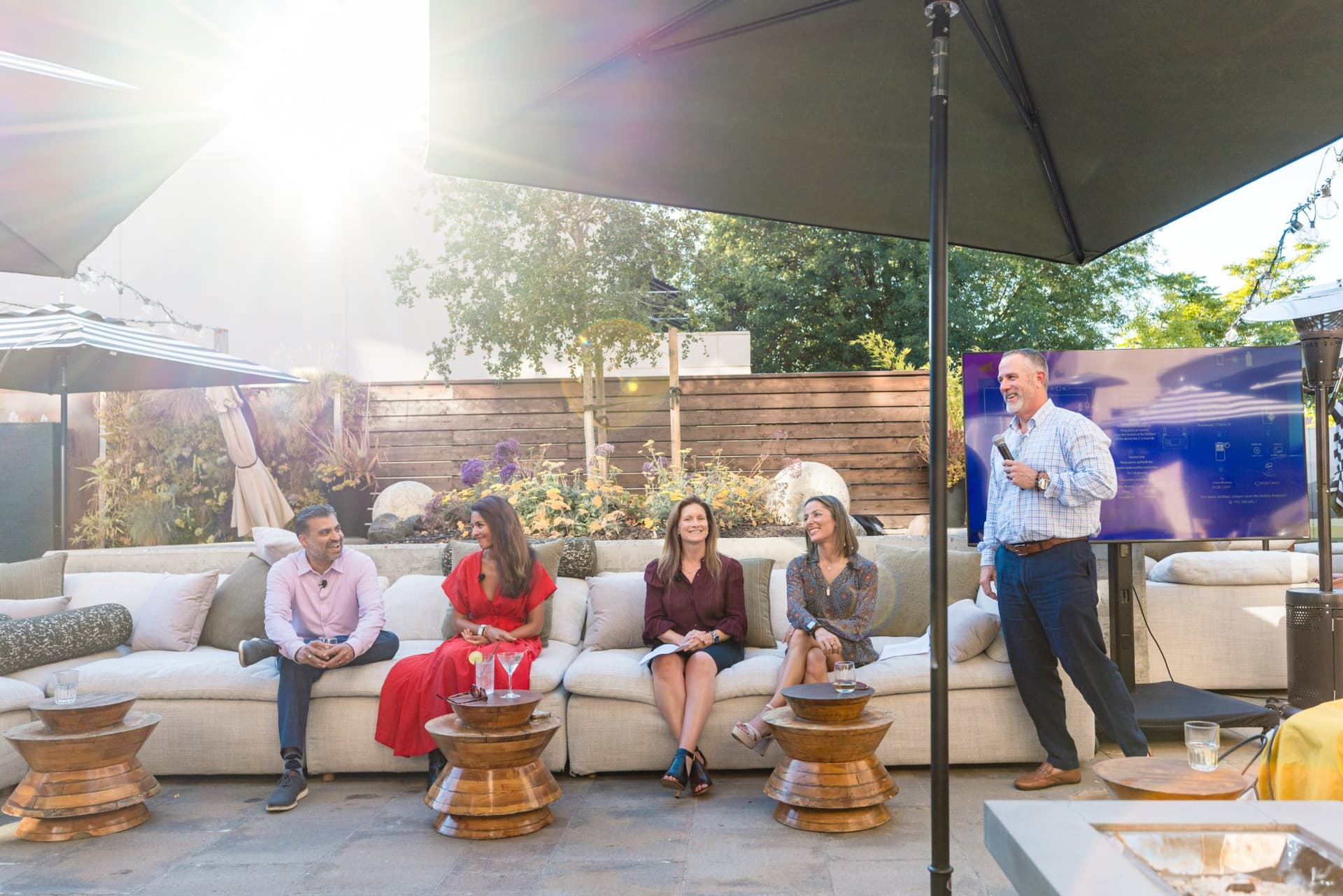 Guests gathered under the patio umbrellas for the Magnus networking reception in Palo Alto