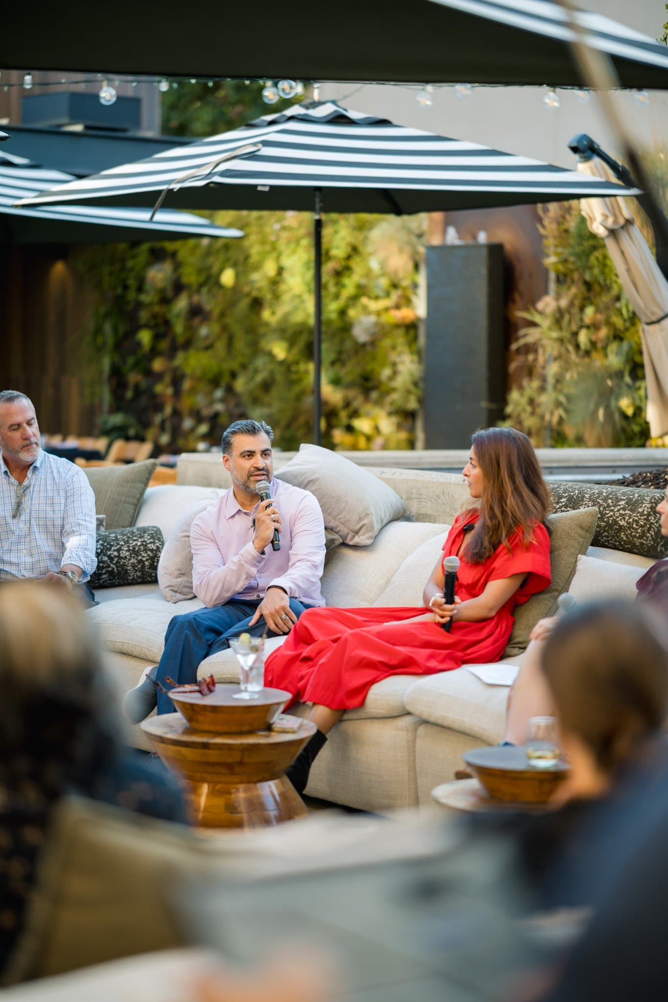 Fireside chat guest speakers seated on the patio sofa at the Magnus networking event in Palo Alto