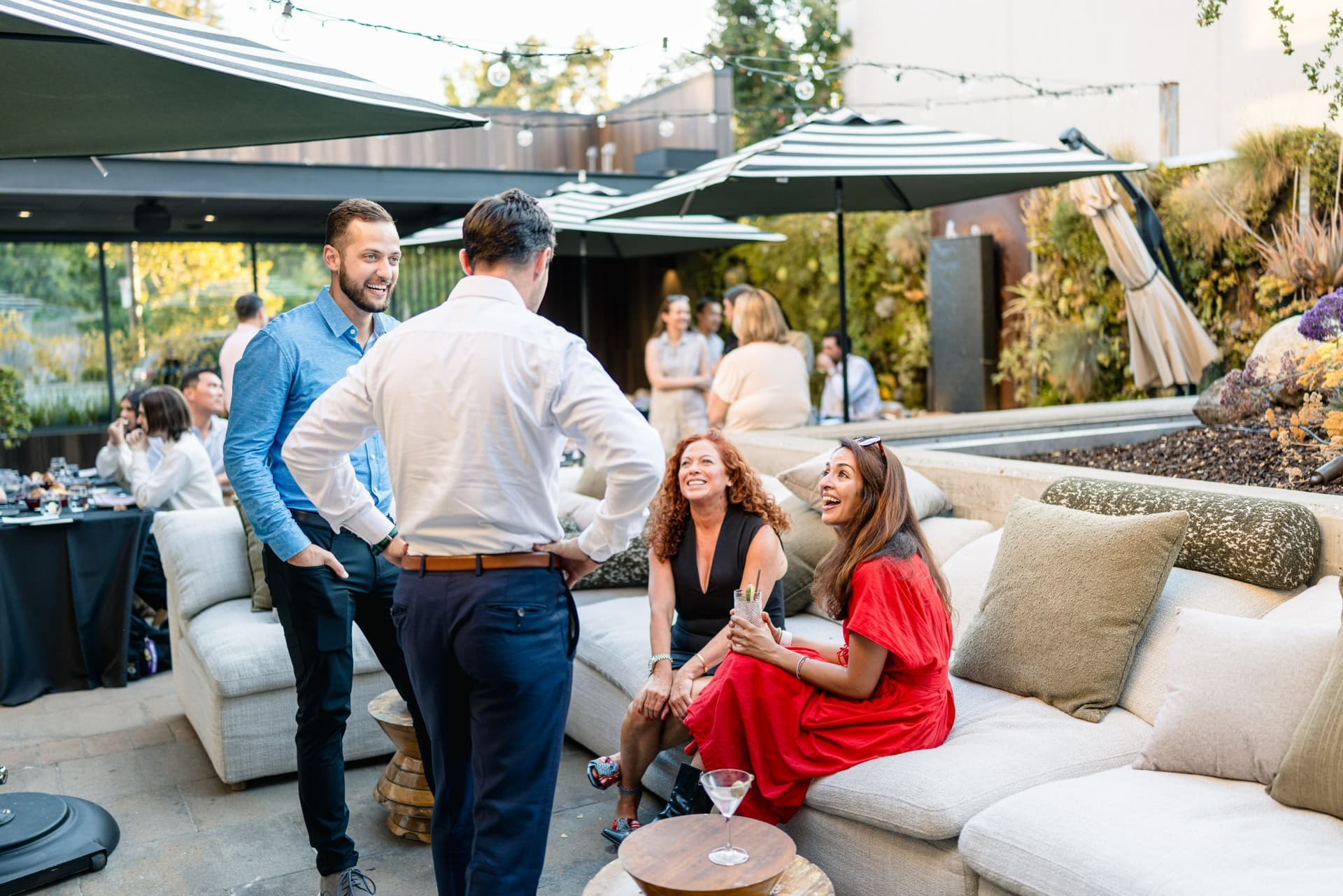 Three-person fireside chat panel seated on the patio sofa at the Magnus event in Palo Alto