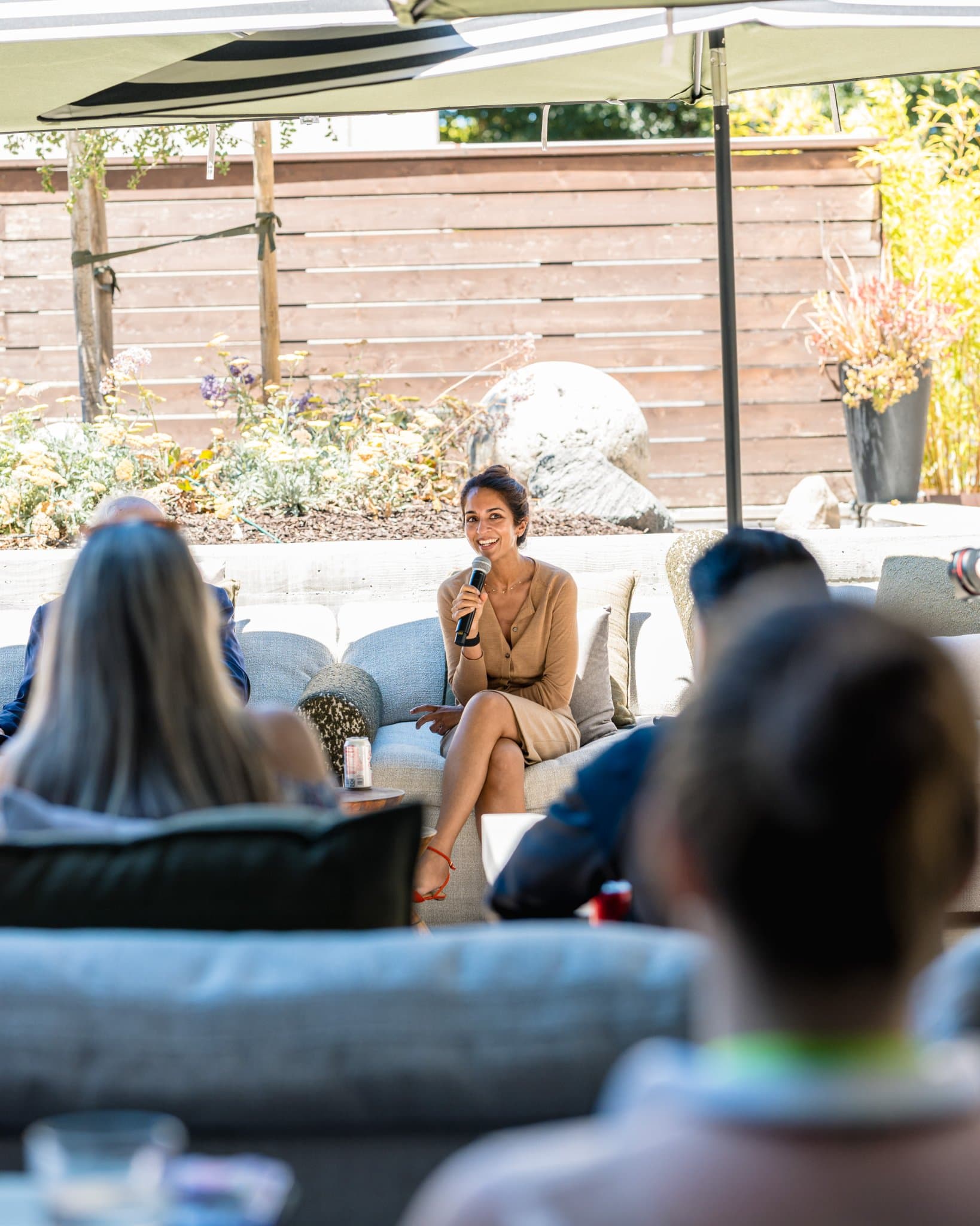 Attendee in a Magnus branded jacket listening to remarks near the garden wall in Palo Alto