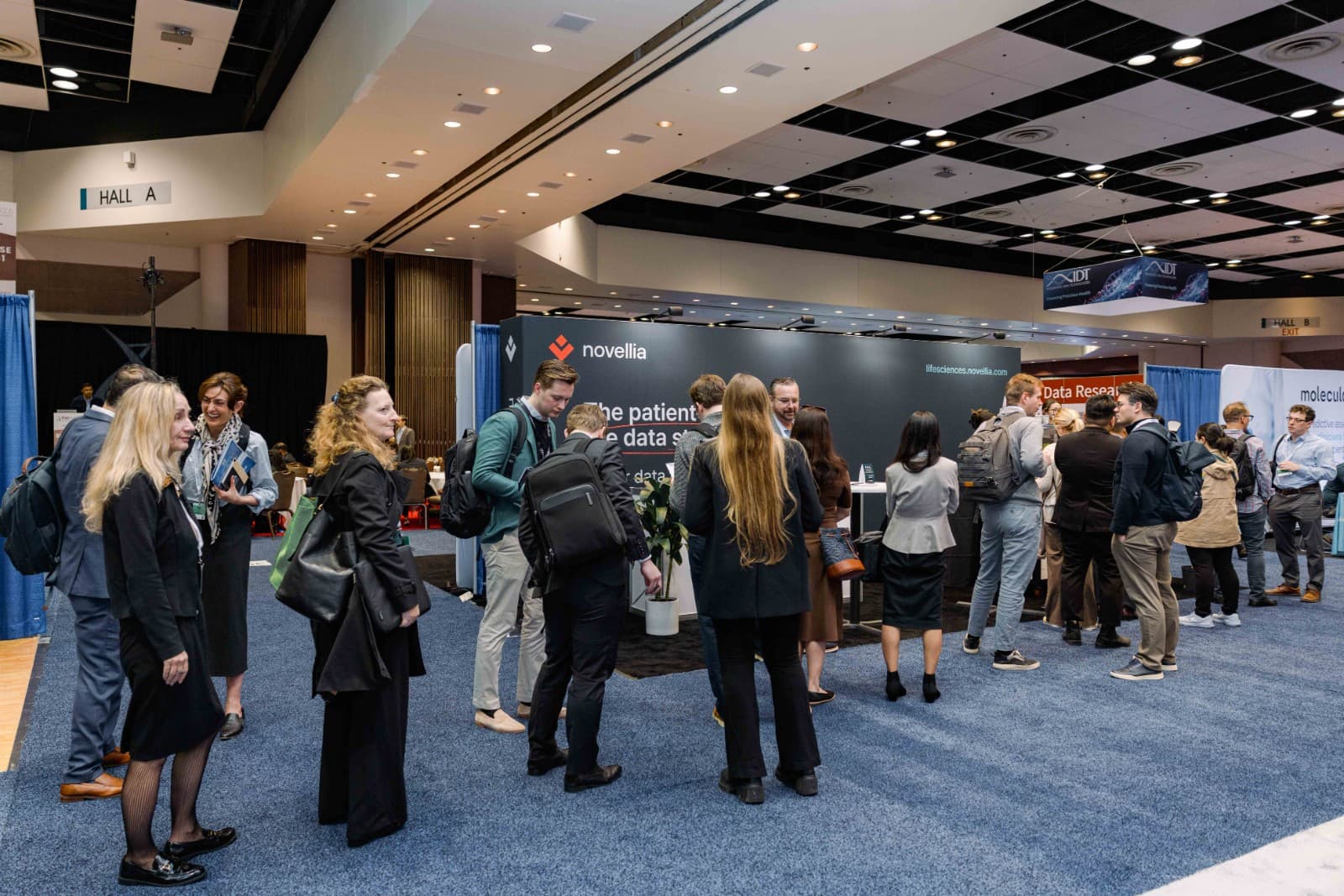 Conference attendees engaging with Novellia representatives at PMWC 2026 in Santa Clara by JY Studio