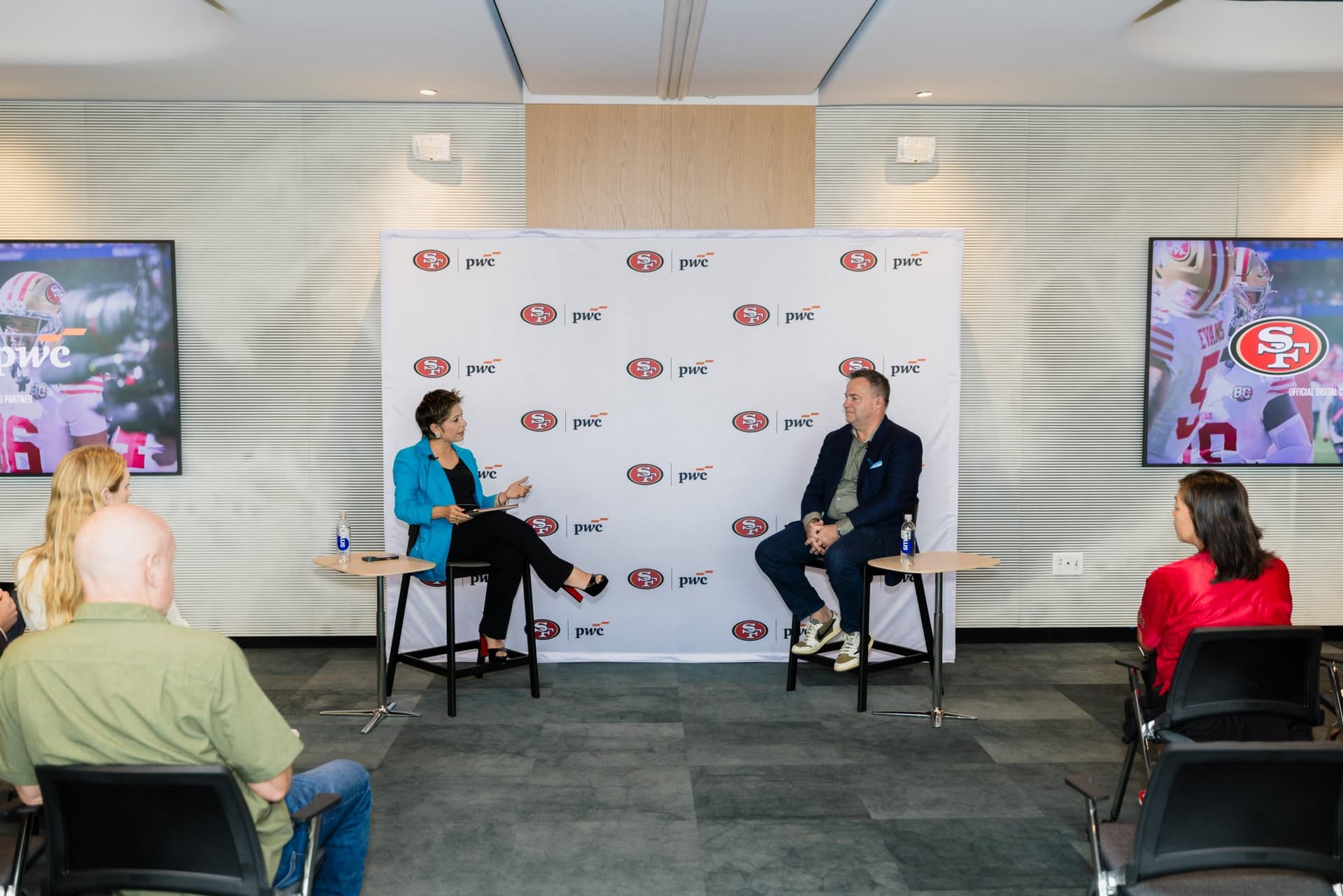 Wide view of the fireside chat with the moderator and guest speaker as attendees watch at the PwC x 49ers event at PwC Silicon Valley in San Jose by JY Studio