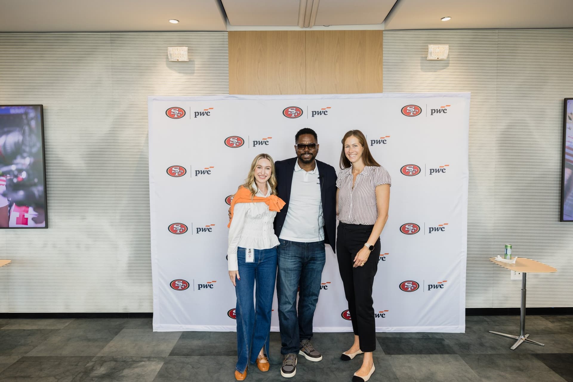 49ers legend posing with two PwC team members in front of the step-and-repeat at the PwC x 49ers event at PwC Silicon Valley in San Jose by JY Studio