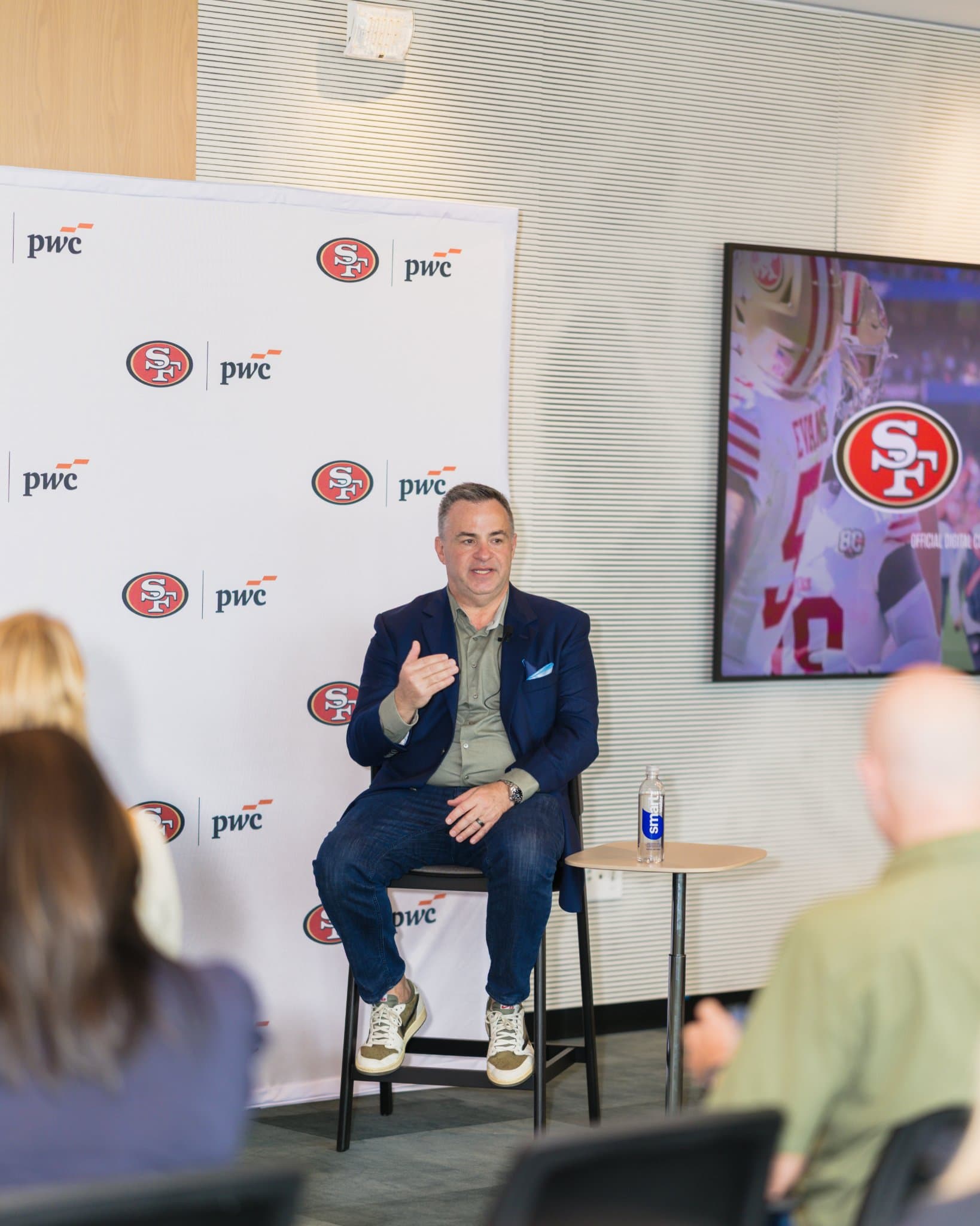 Guest speaker gesturing while sharing a story during the fireside chat at the PwC x 49ers event at PwC Silicon Valley in San Jose by JY Studio