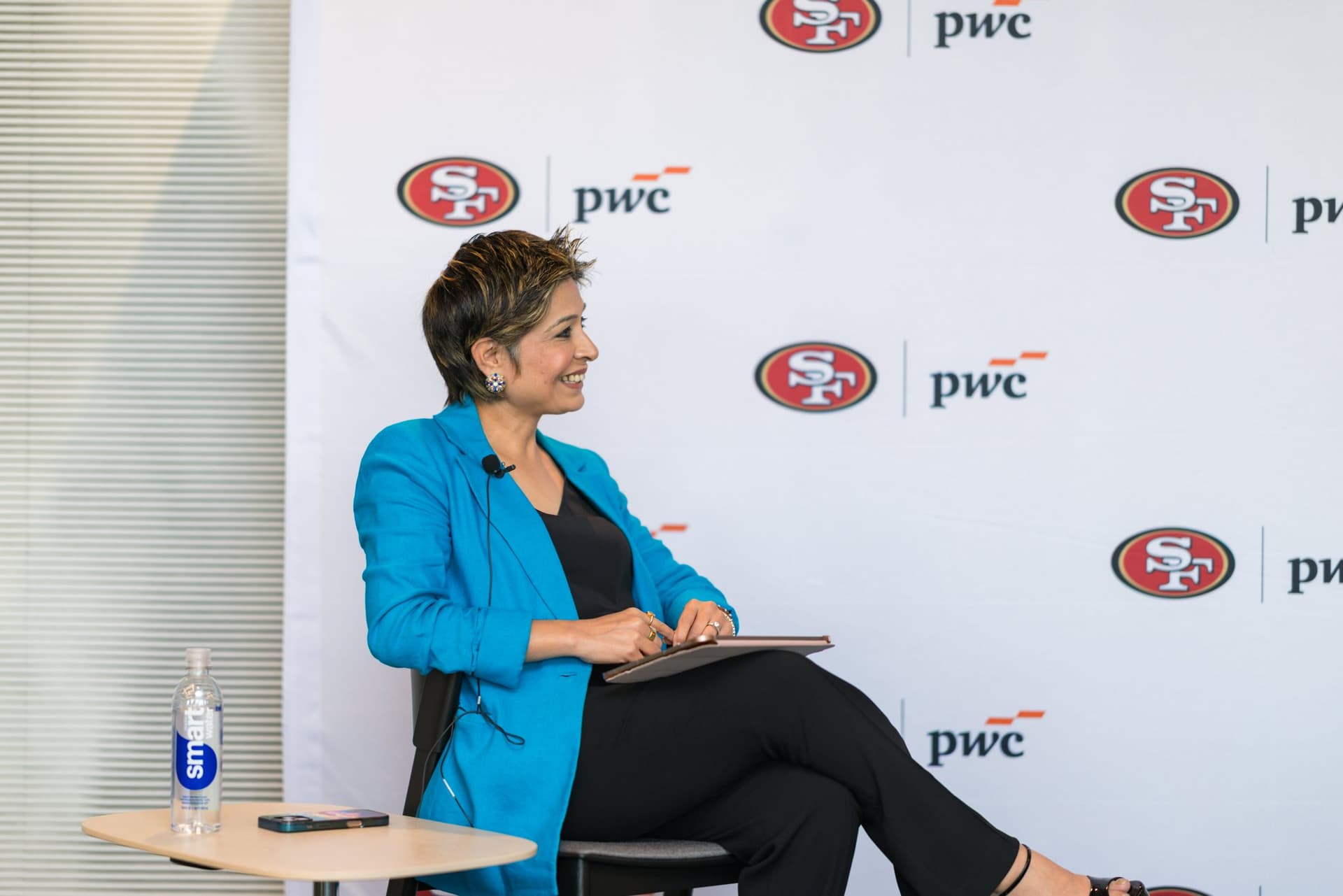 Moderator smiling while listening during the fireside chat at the PwC x 49ers event at PwC Silicon Valley in San Jose by JY Studio