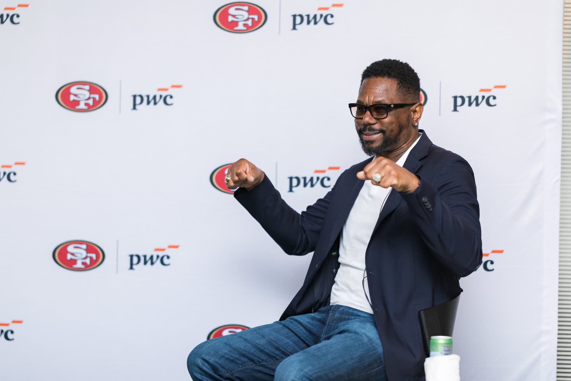49ers legend showing his championship ring while making a point on stage at the PwC x 49ers event at PwC Silicon Valley in San Jose by JY Studio