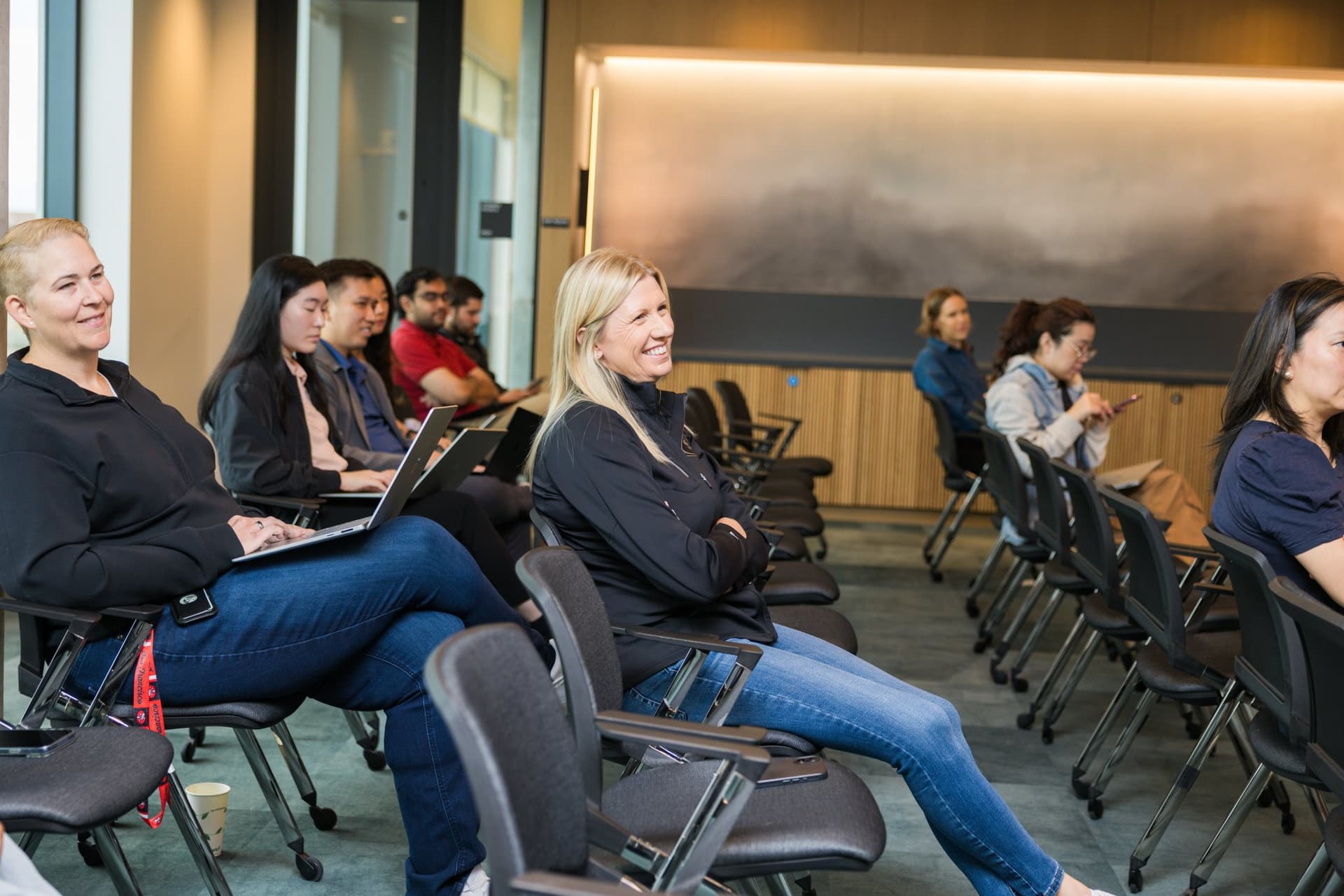 Attendees smiling and laughing during the fireside chat at the PwC x 49ers event at PwC Silicon Valley in San Jose by JY Studio