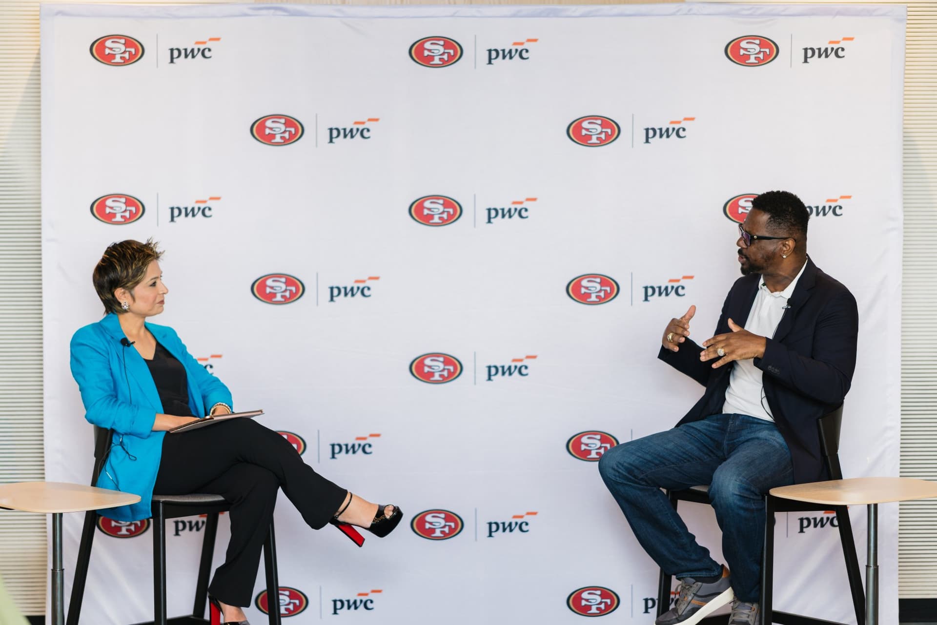 Moderator listening as the 49ers legend explains a point during the fireside chat at the PwC x 49ers event at PwC Silicon Valley in San Jose by JY Studio
