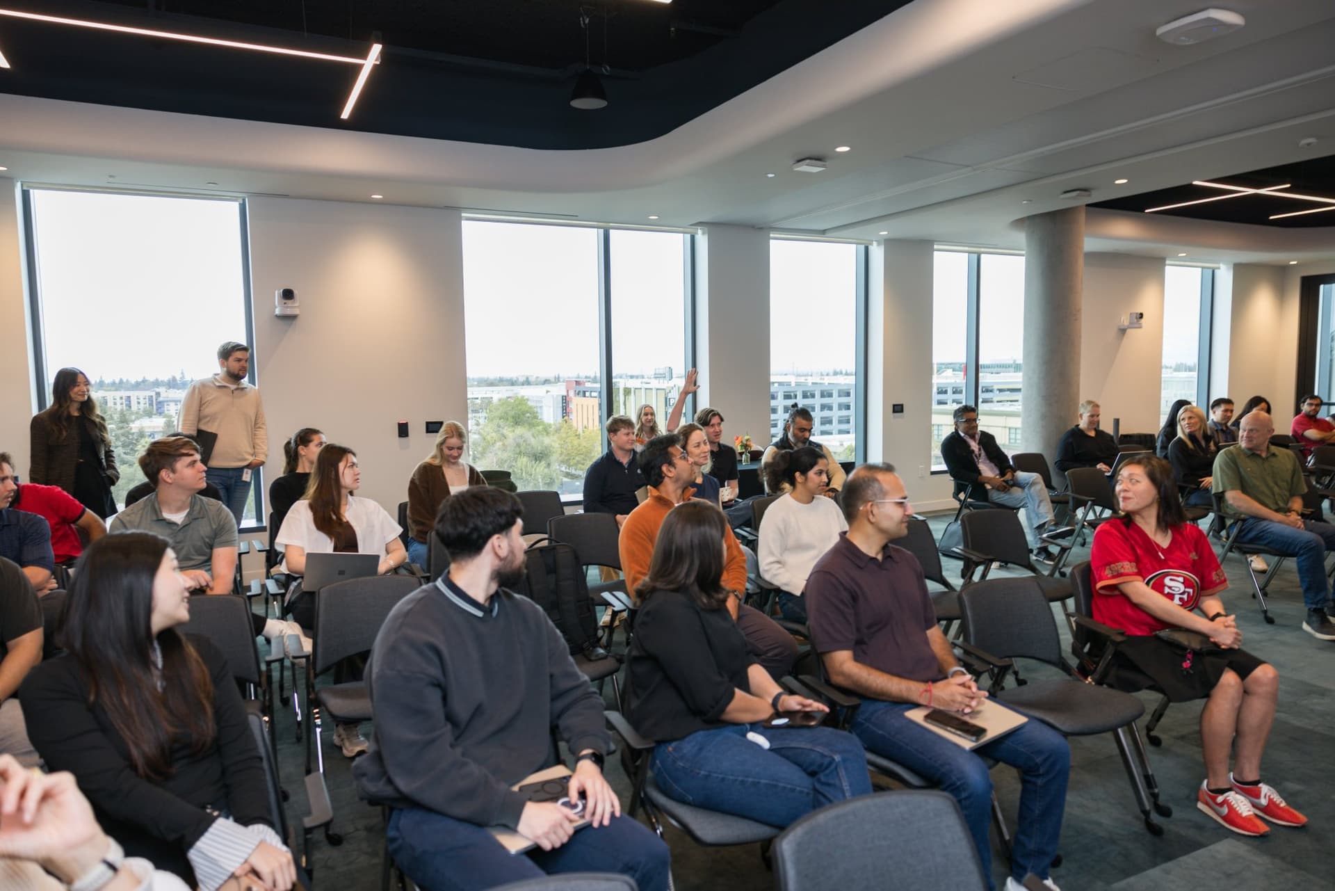 Wide view of a packed room of attendees during the fireside chat at the PwC x 49ers event at PwC Silicon Valley in San Jose by JY Studio